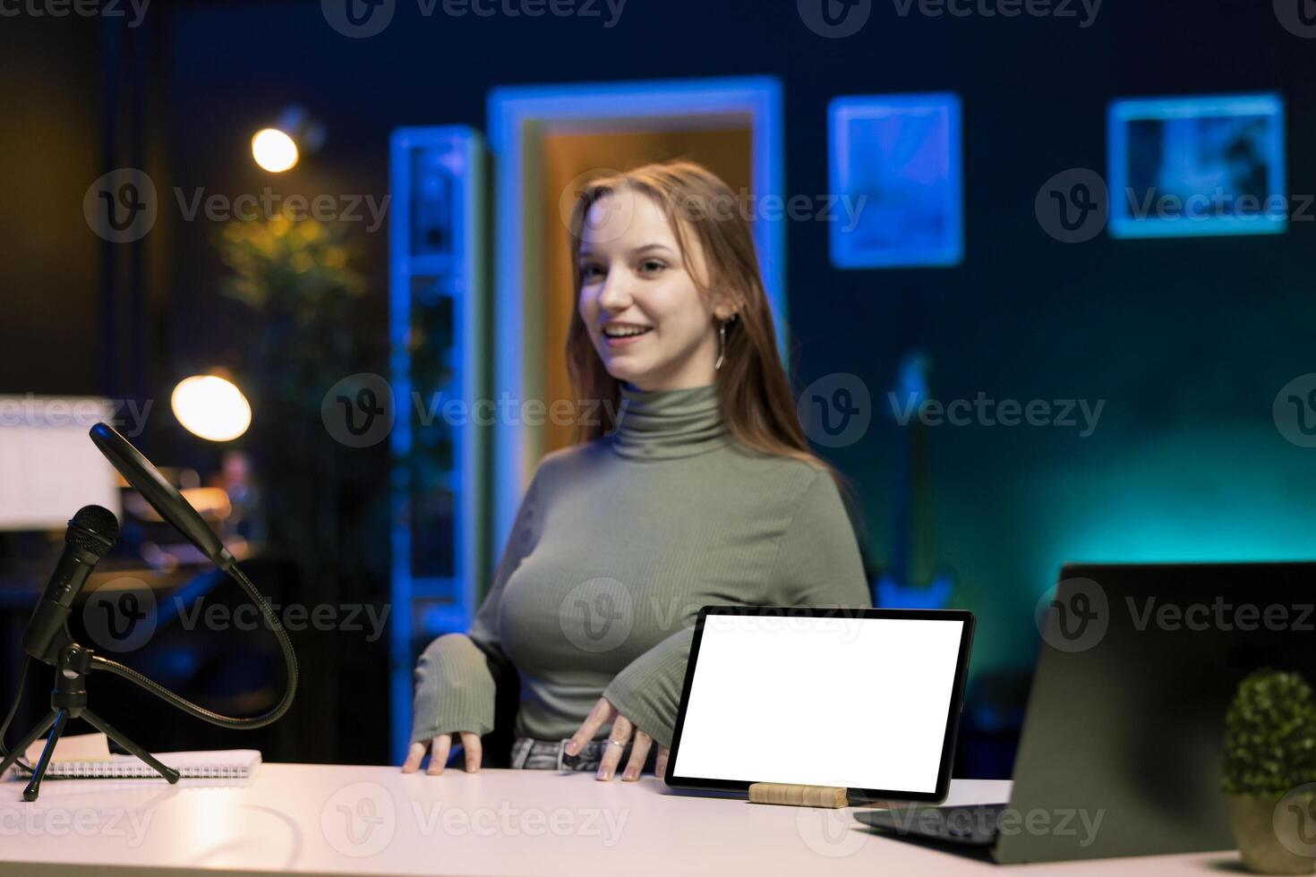 Joyful teenage entertainer presenting mockup tablet in entry level low budget price range for viewers. Gen Z media star reviewing isolated screen portable device in front of internet subscribers photo