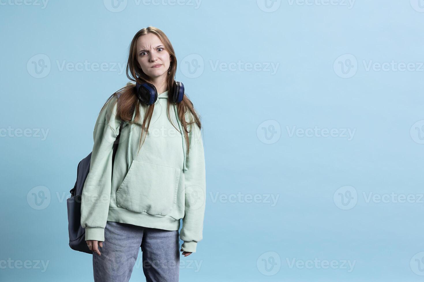 Young actress goofing around, switching emotions, trying different facial expressions, practicing for theatre class, isolated over studio background. Teenage woman making silly faces, photo