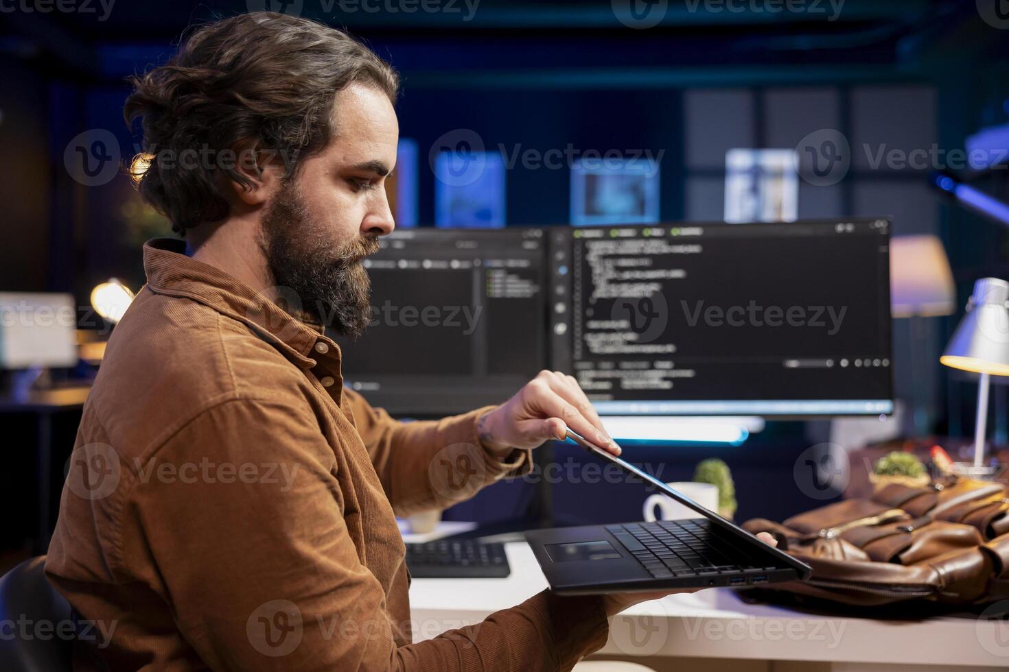 Programmer closing laptop, ready to go home after designing and developing software applications. IT professional packing notebook after implementing and maintaining company systems photo
