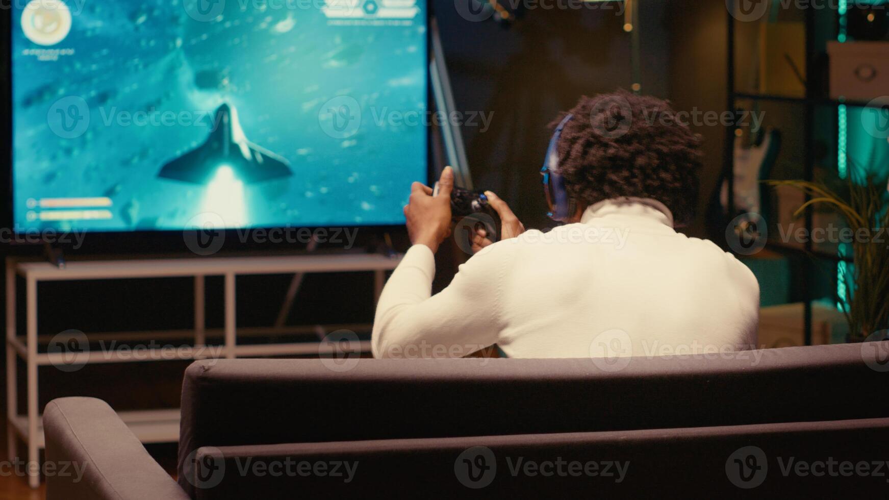 Player in home theatre enjoys game with spaceship shooting laser streams using crosshair overlay to hit enemies. Ray tracing graphics and high FPS SF videogame displayed using projector photo