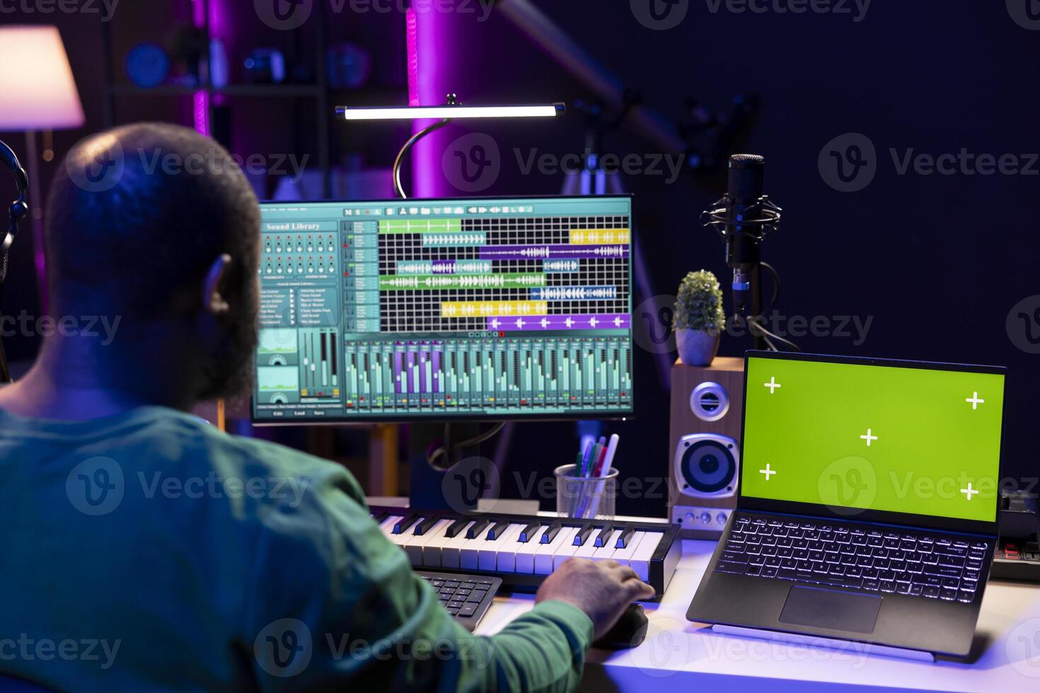 Music producer mixing and mastering songs on digital post production pc interface, greenscreen display. Artist adding sound effects and adjusting volume levels to produce new music. photo