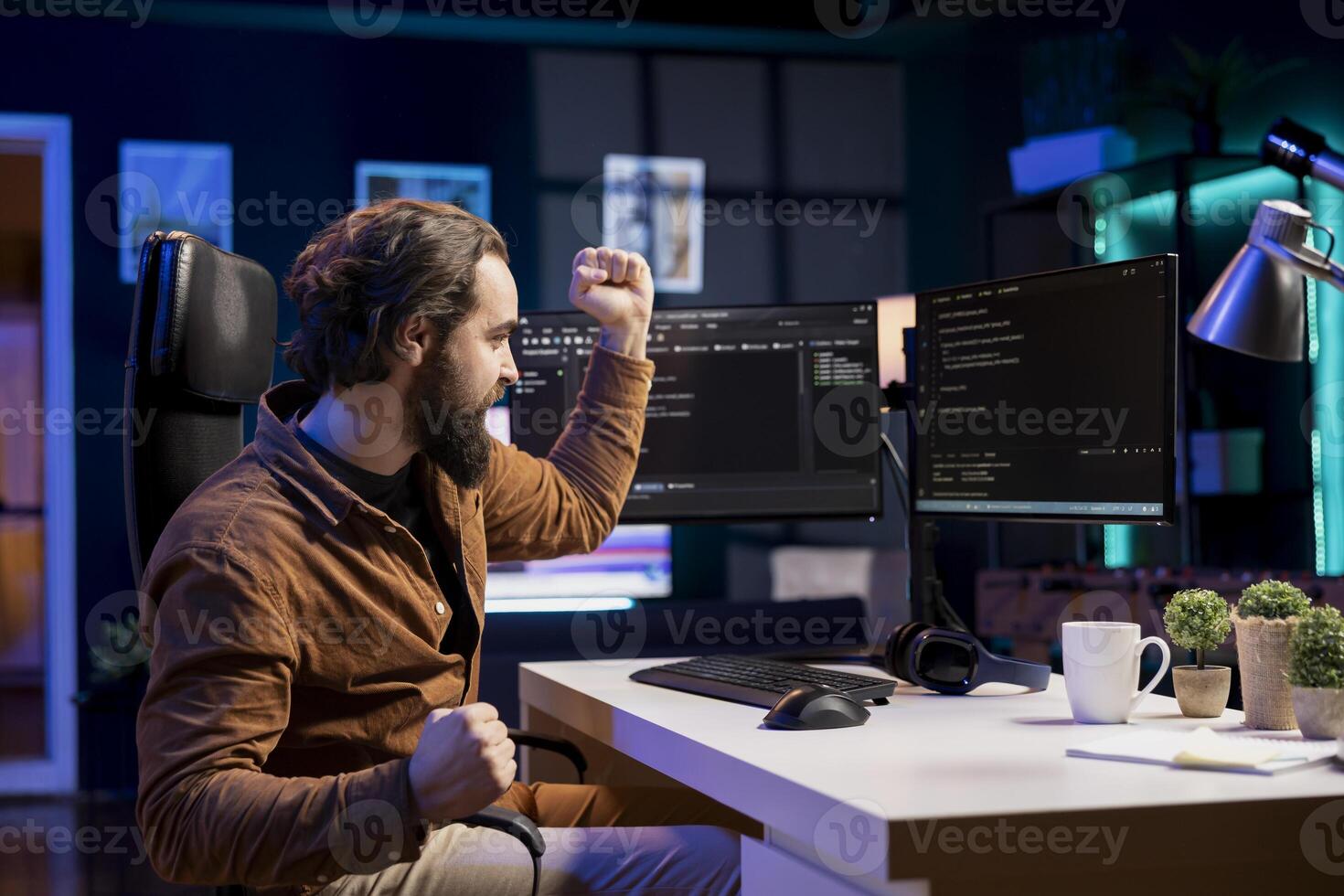 Ecstatic computer engineer celebrating after futureproofing company network from downtimes and unexpected system failures. Euphoric IT admin delighted after managing to increase data security photo