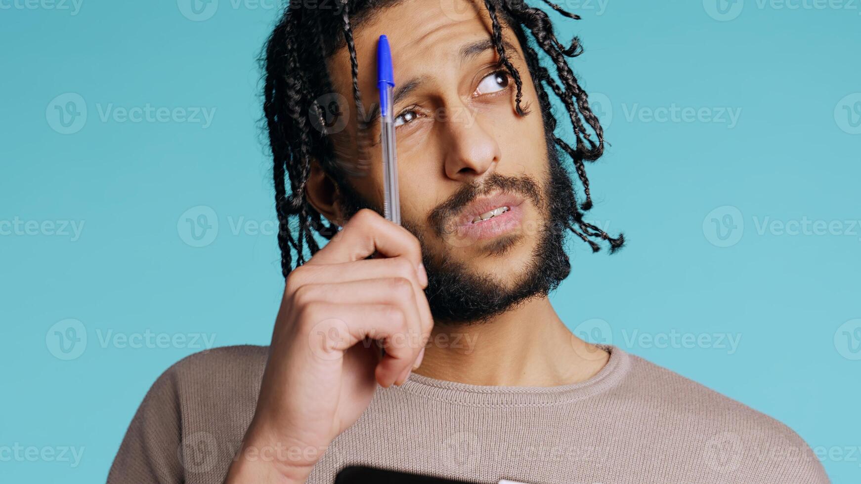 Portrait of man deliberating, putting pen on lips, coming up with idea concept. Thoughtful person reflecting, doing brainstorming, having eureka moment, studio background, camera B close up photo