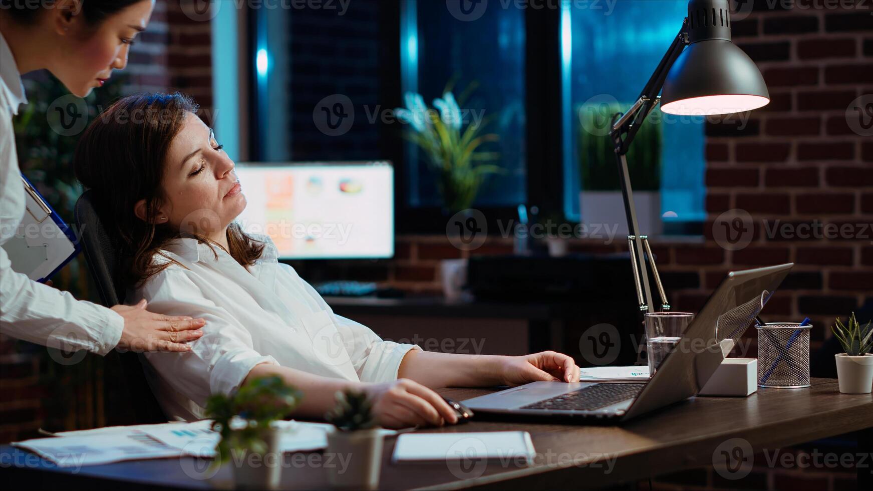 Tired employee sleeping on workspace desk, awaken by manager, excusing herself. Drowsy businesswoman woken up by team leader after napping in office working overnight, feeling ashamed, camera B photo
