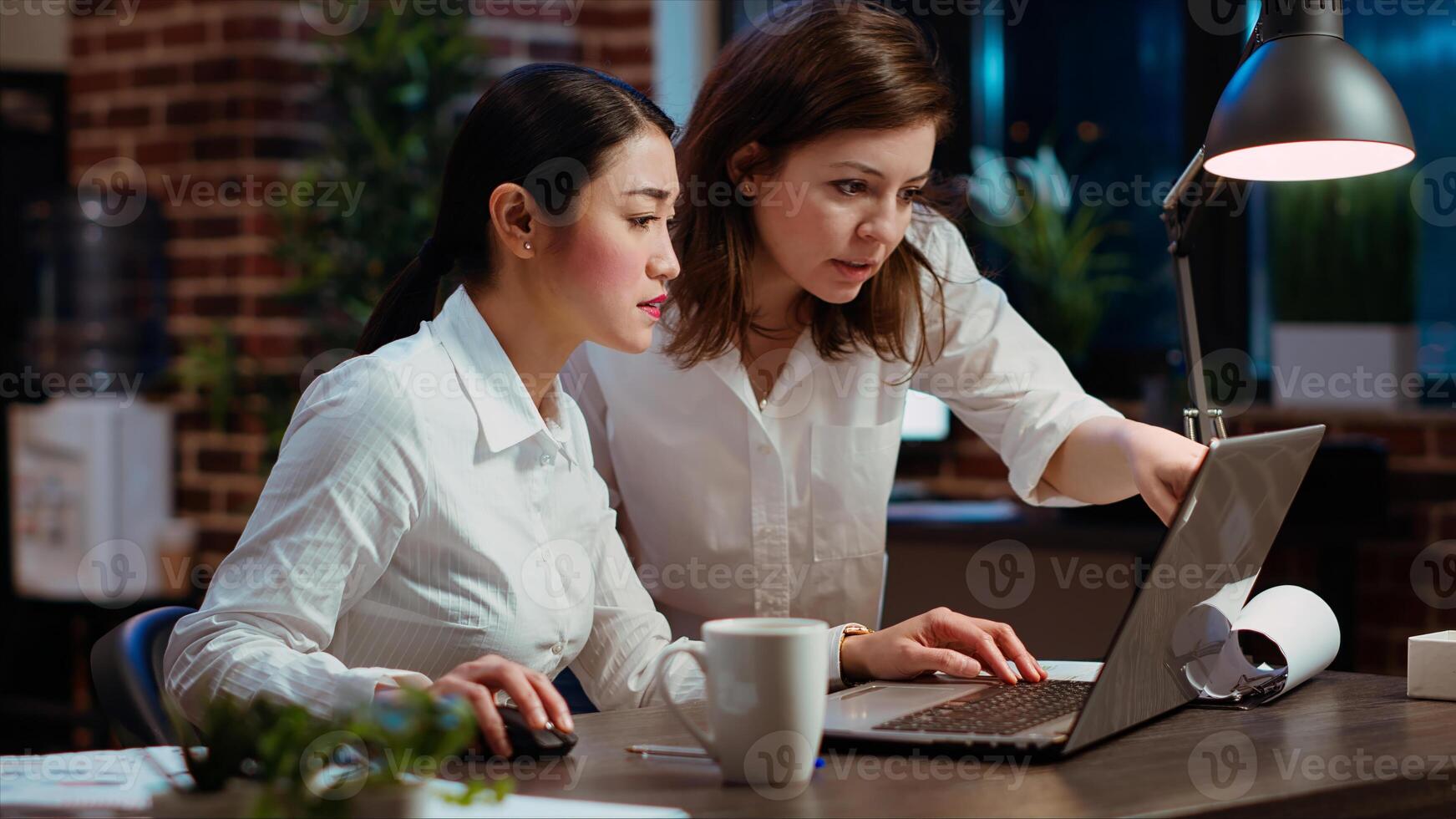 Asian employee brainstorming with coworker to compose email at computer desk, finalizing deal with business partners. Businesswoman and colleague closing agreement with associates, camera B photo