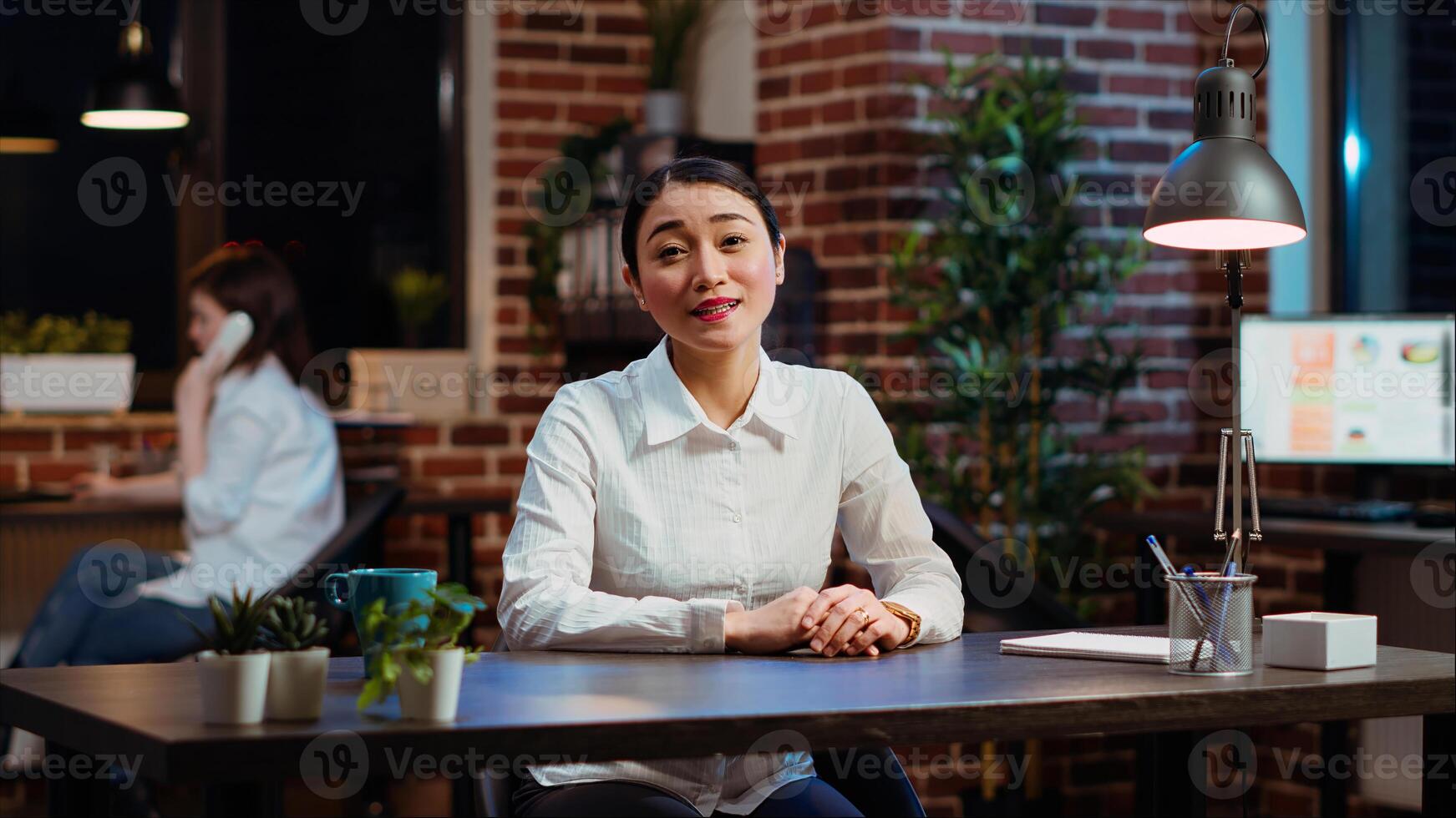 POV of smiling asian worker greeting colleagues during business meeting on videocall in office. Portrait of friendly employee participating in remote videoconference telework call photo