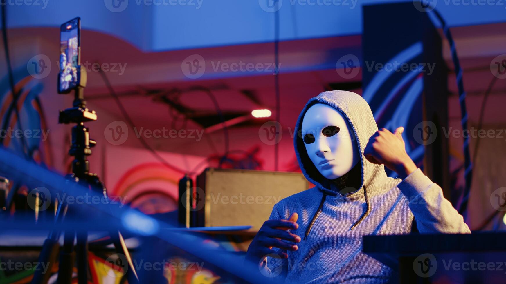 Malicious hacker filming threatening to destroy country government firewall and create chaos if his demands are not met. Rogue programmer using phone to record blackmail message photo