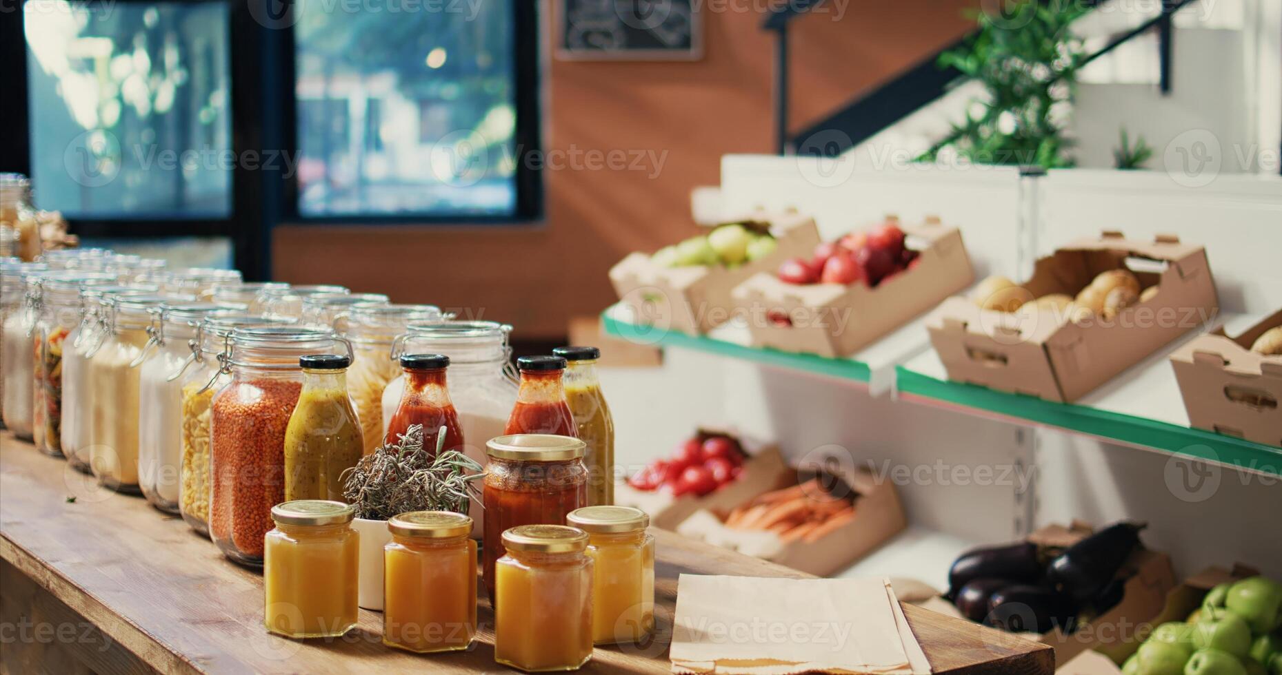 Bulk merchandise in reusable glass jars sold at zero waste store to protect environmental changes, natural homemade sauces. Eco friendly market with organic grains, spices and cereals. Handheld shot. photo