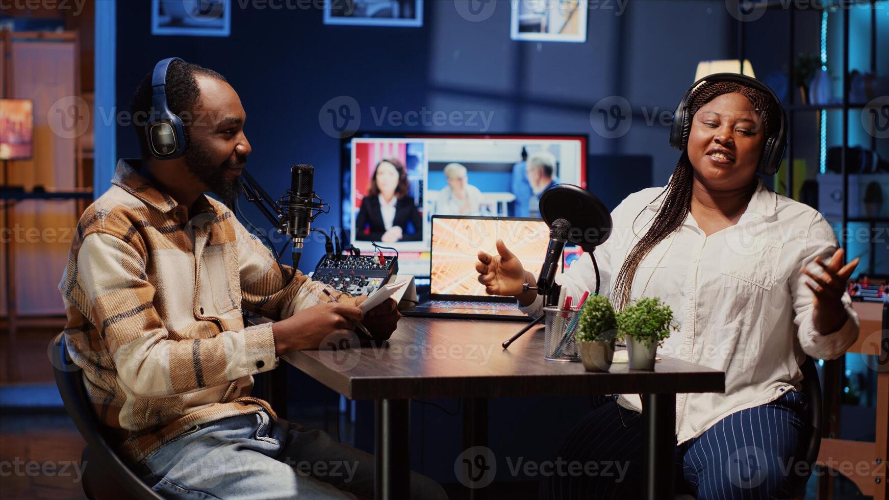 Vlogger show host and guest talking in neon lights ornate living room personal studio. Man and woman broadcasting discussion on online podcast episode using professional equipment. photo