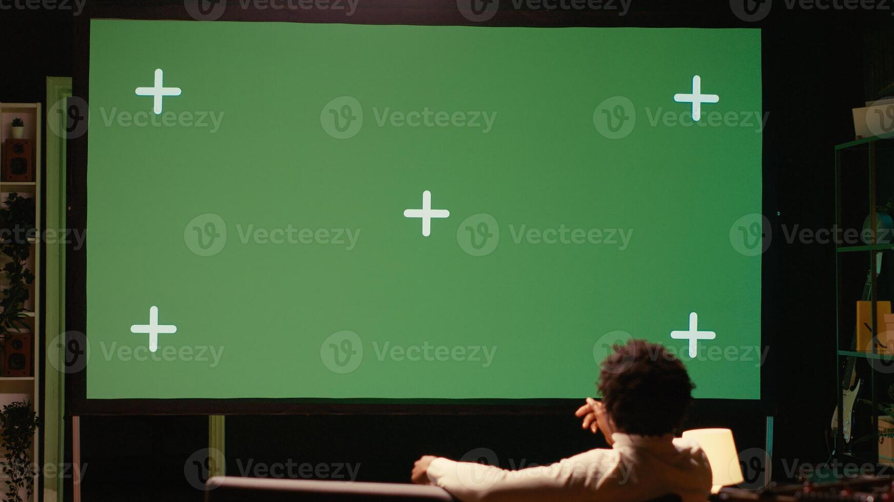 Man using streaming services on ultrawide chroma key TV to binge watch series from the comfort of his apartment. Cord cutter enjoying shows on television set during leisure time on couch photo