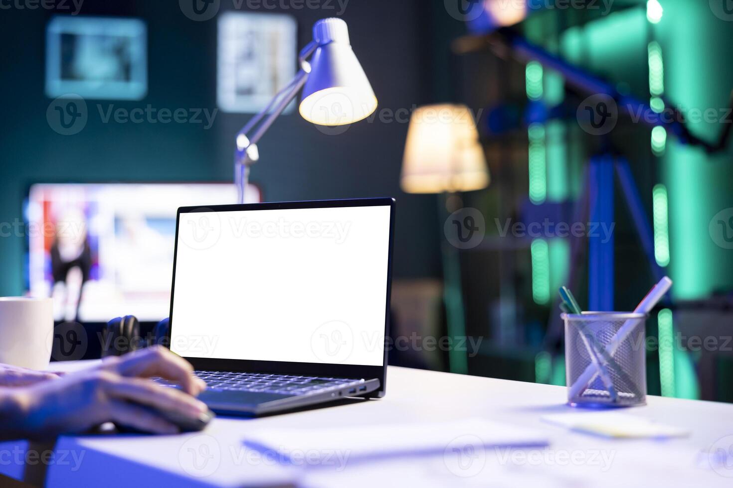 Closeup of person using a laptop showing isolated copyspace mockup template. An individual utilizing an electronic device on the table that is displaying a blank white screen. photo