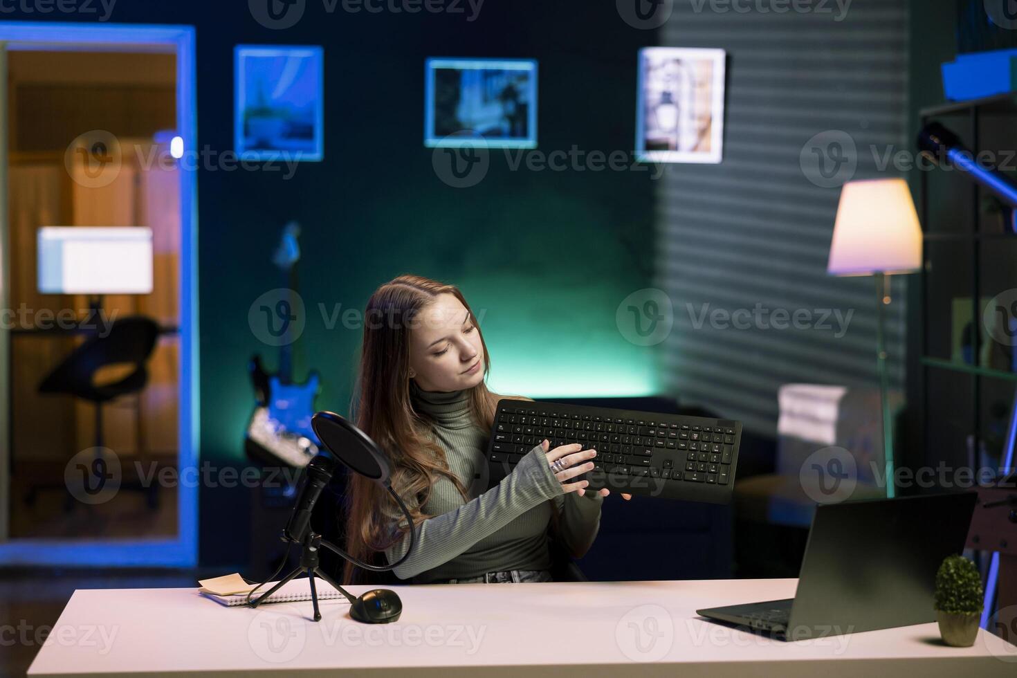 Entertainer presenting keyboard from brand sponsoring , urging viewers to buy it. Girl does influencer marketing by advertising computer peripherals to audience in studio photo