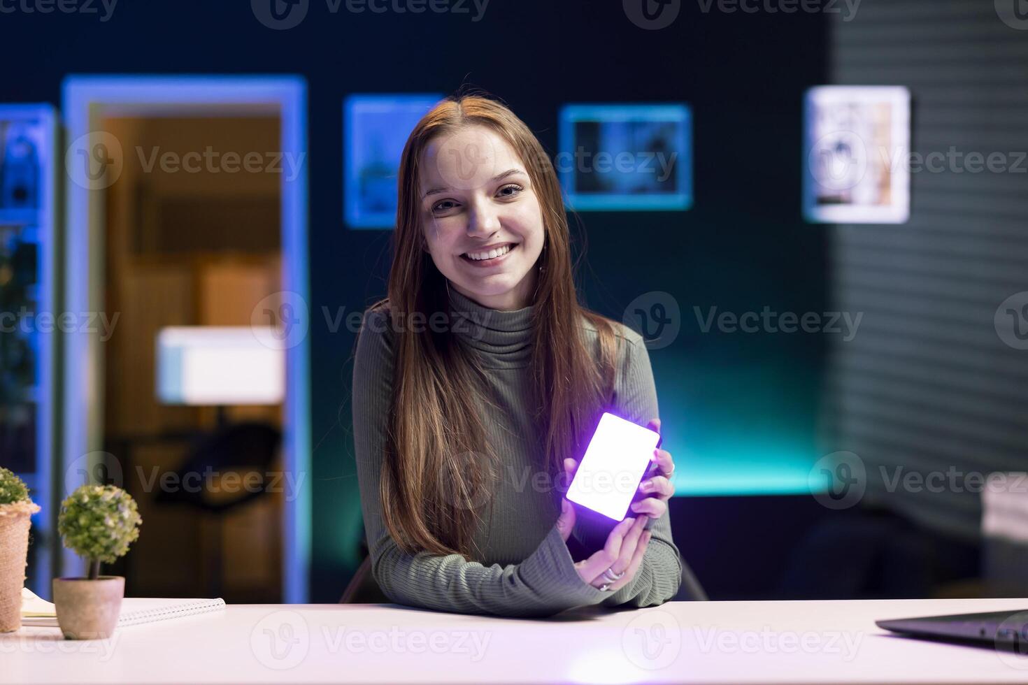 Portrait of smiling influencer in studio using camera to capture live broadcast, reviewing mini RGB lights. Cheerful internet show host films electronics haul, presenting wireless LED lighting device photo