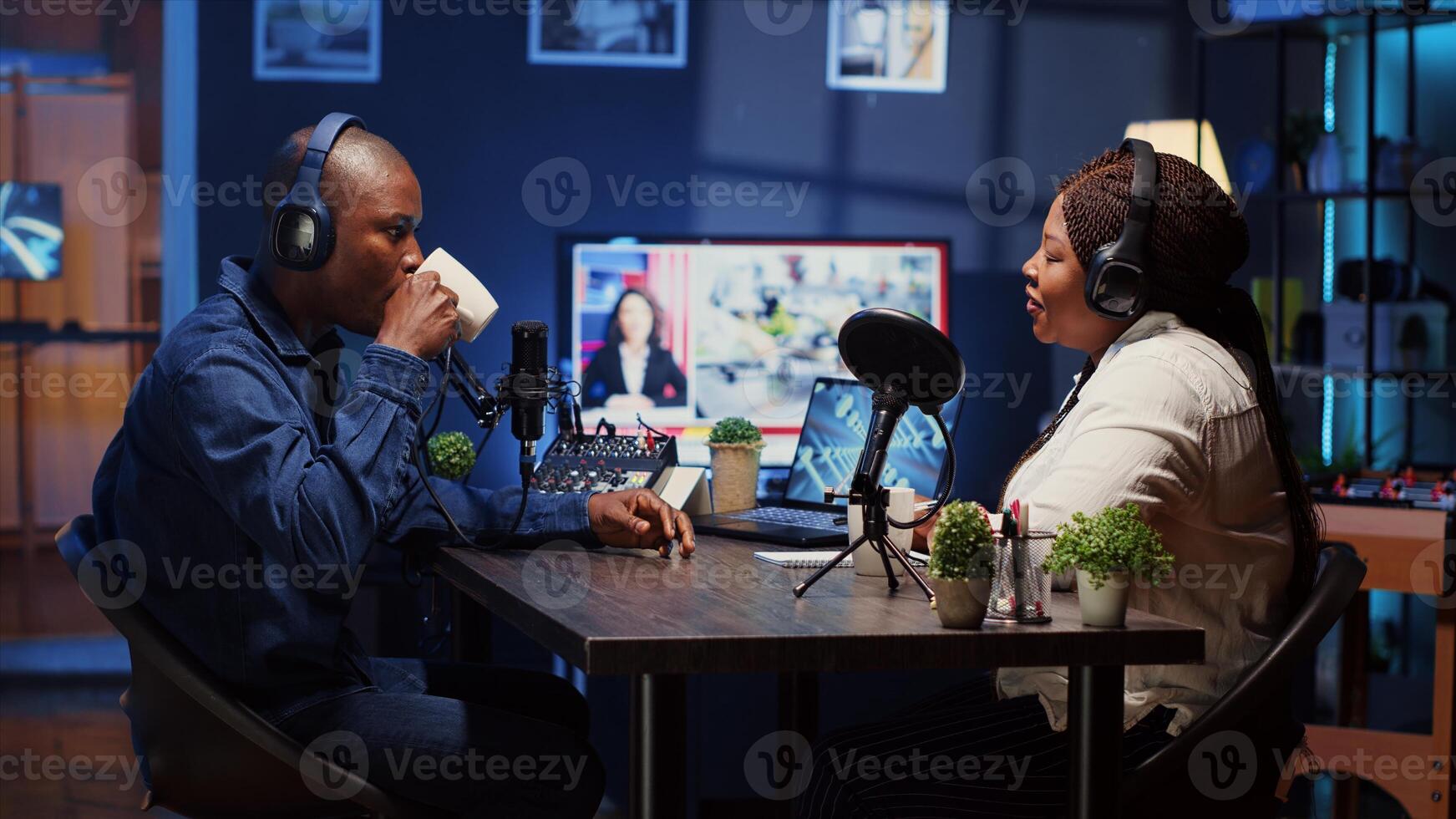 Show host recording podcast, enjoying cup of coffee and nice conversation with guest. African american man using professional audio devices for flawless sound quality while live chatting with woman photo