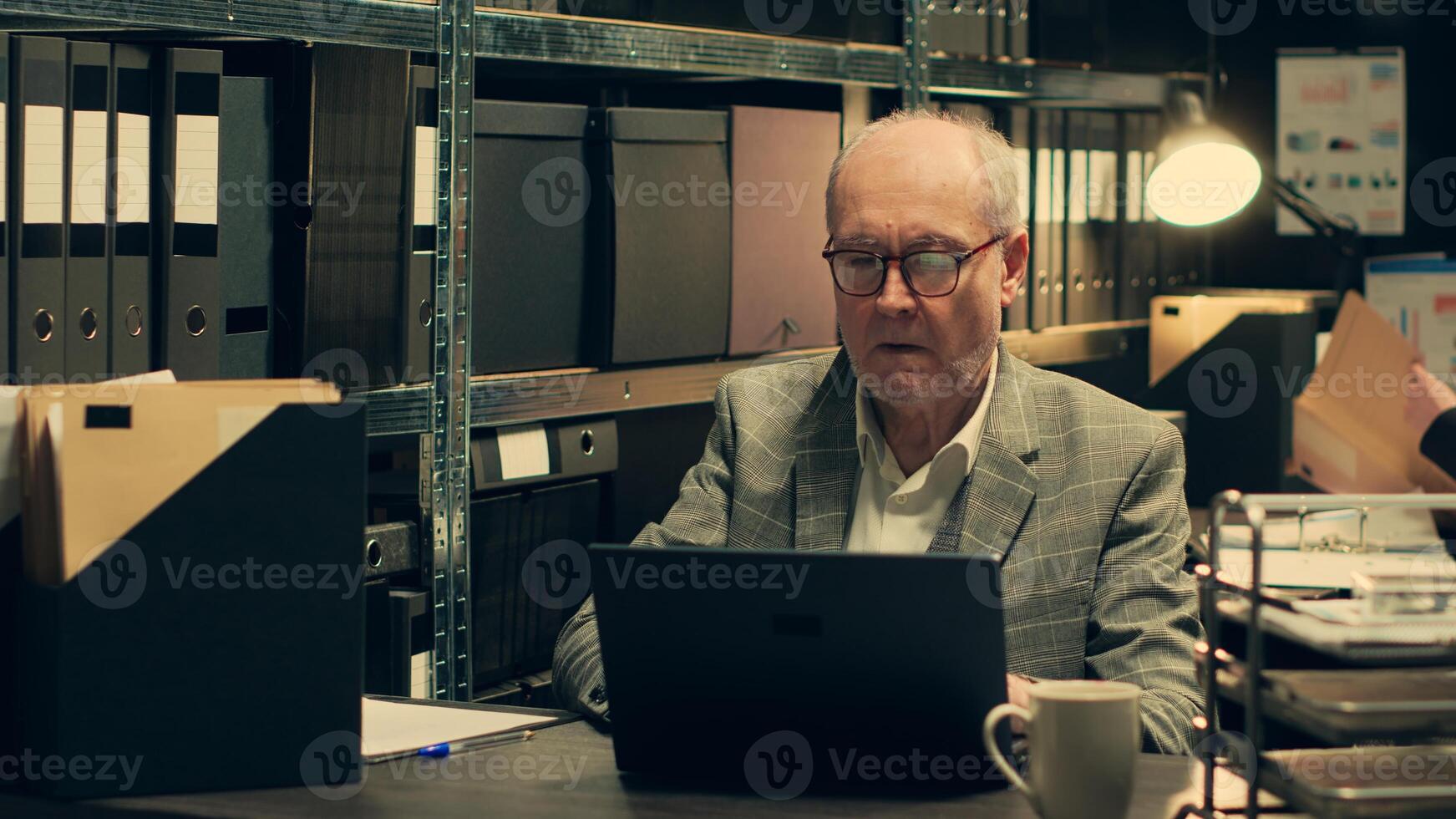Senior inspector identifying patterns in criminal behavior by analyzing classified files and legal documents. Private detective looking at forensic evidence in hope on finding clues. Camera A. photo