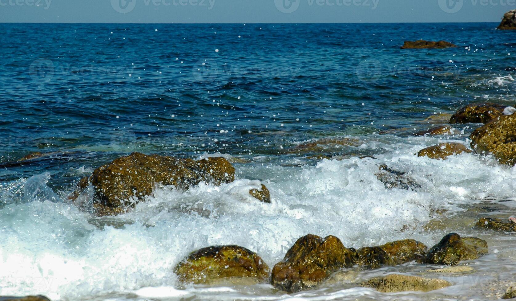 White waves on stones near the shore near the steep limestone shores and rocks in the tract Dzhangul, western Crimea photo