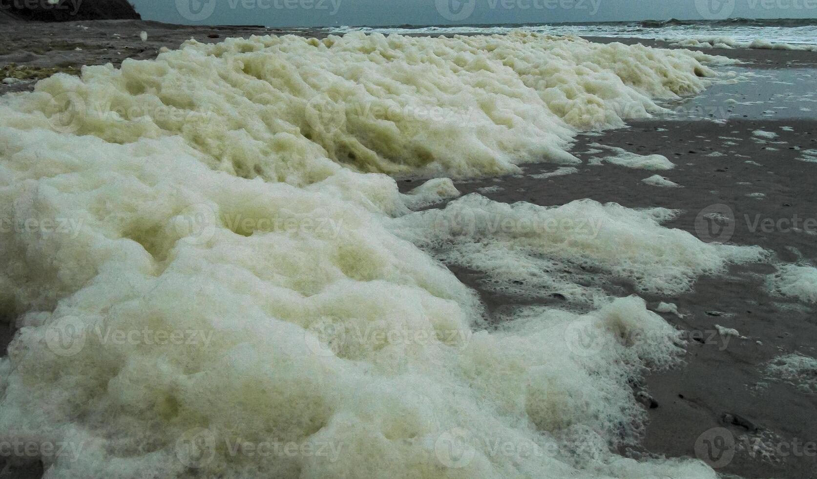 Dirty foam and water pollution and its eutrophication after filling the beaches with sand in the city of Odessa, Ukraine photo