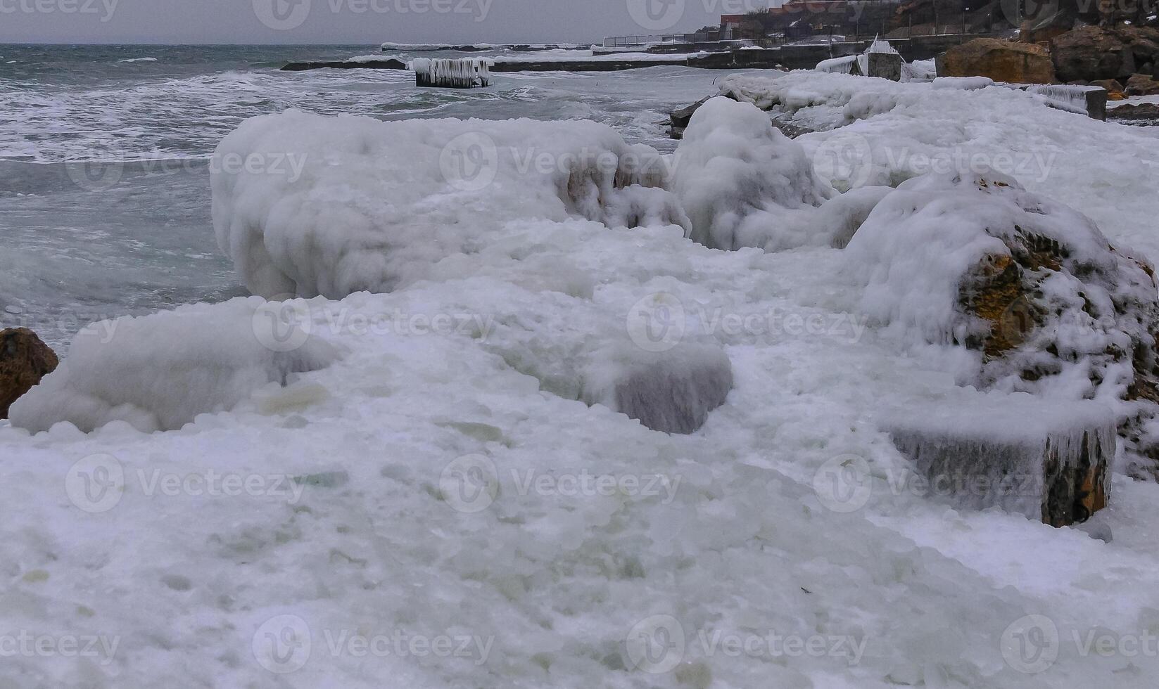 The Black Sea is frozen, the circular ice rolled by the waves is thrown ashore and frozen photo