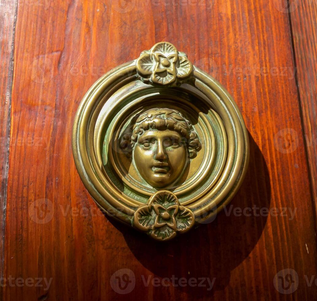 Traditional copper handle and door knocker on wooden doors of old houses in Malta, Gozo photo