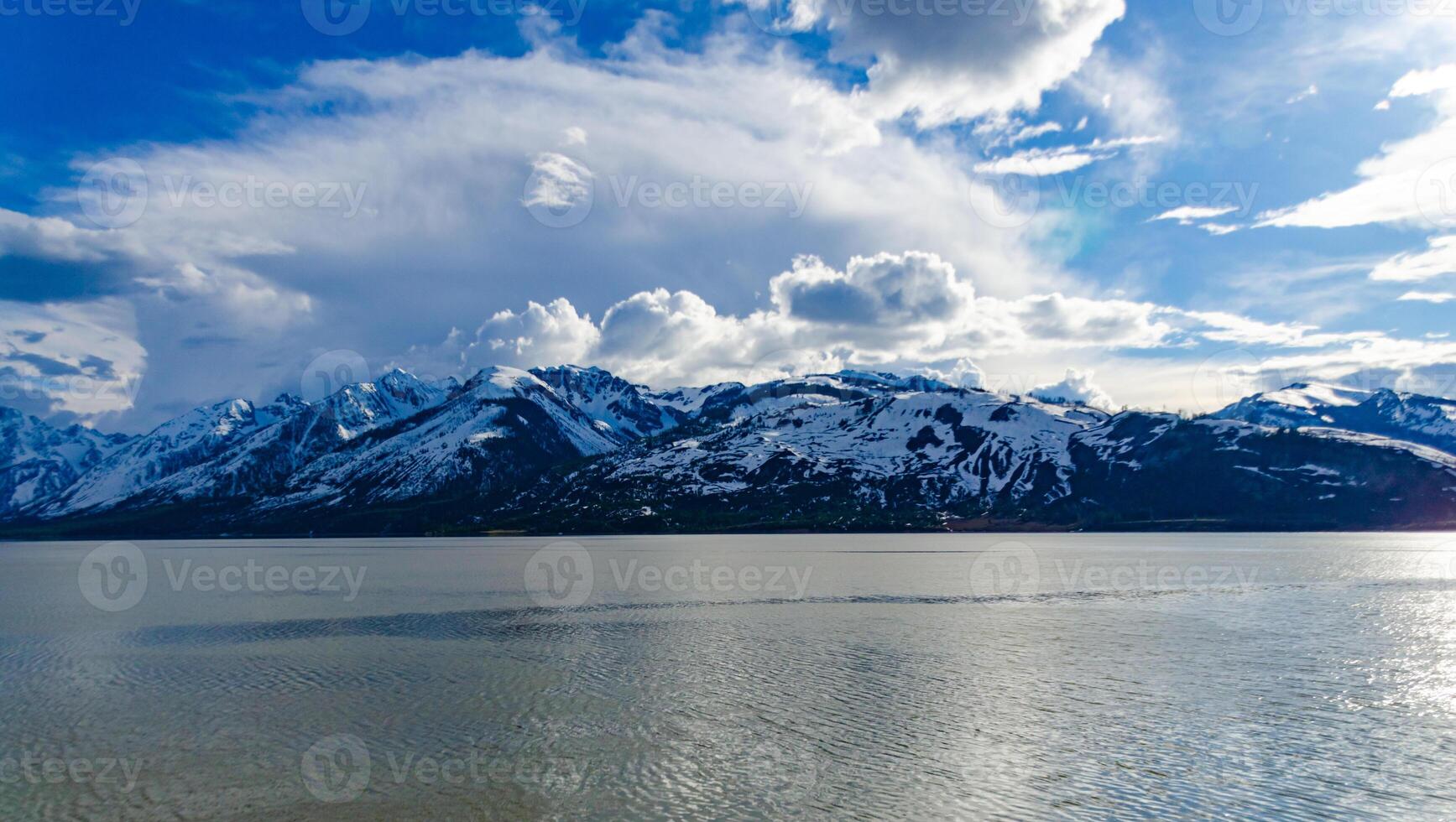 View of the snow-capped mountains in the clouds near the lake Gren Titon, US photo