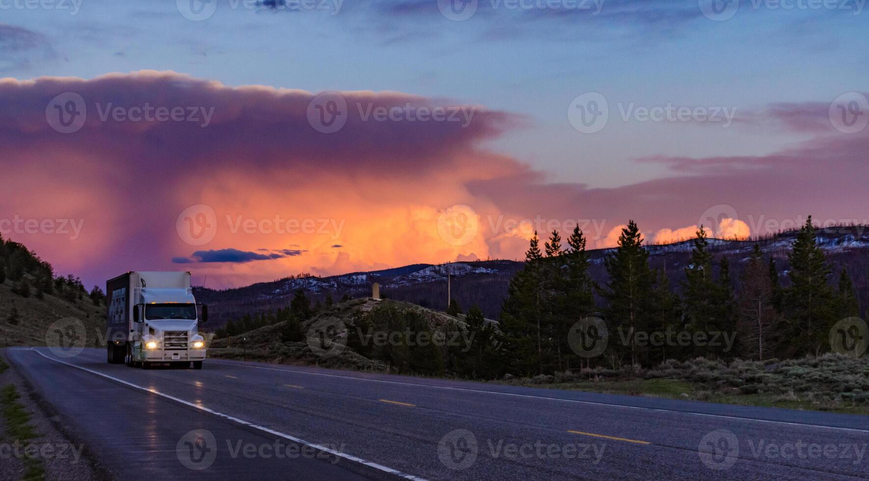 Beautiful red sunset over the mountains, car on the road. US photo
