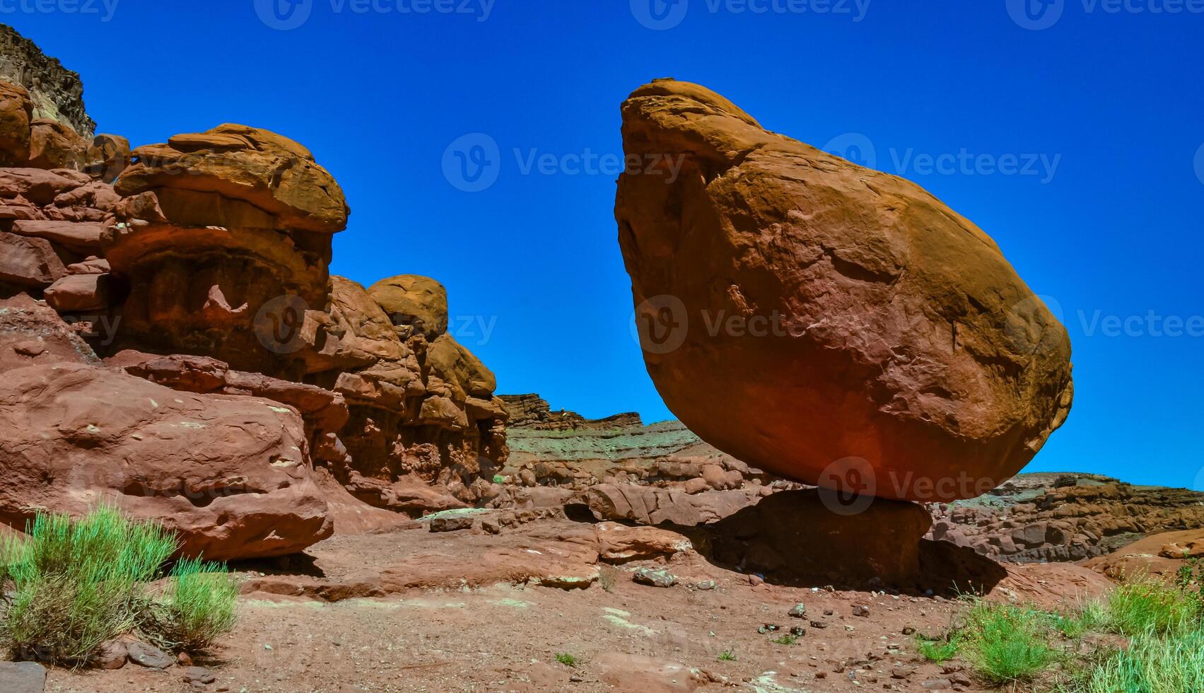 Balancing rock at the bottom of a canyon among Layered geological formations of red rocks. photo