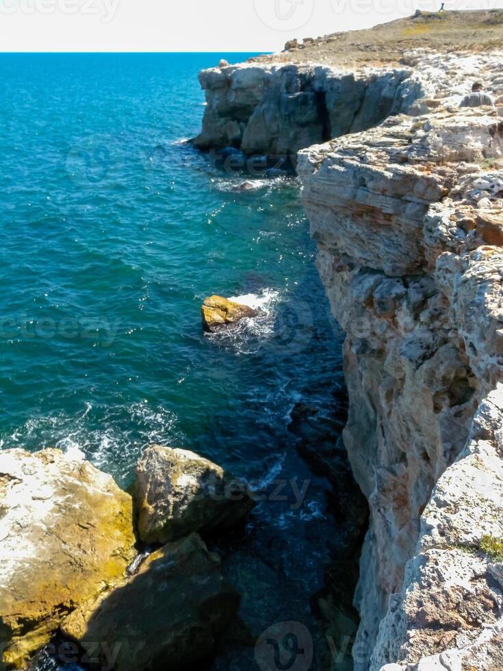 Steep coast with karst caves and grottoes near the village of Tyulenovo, Bulgary photo