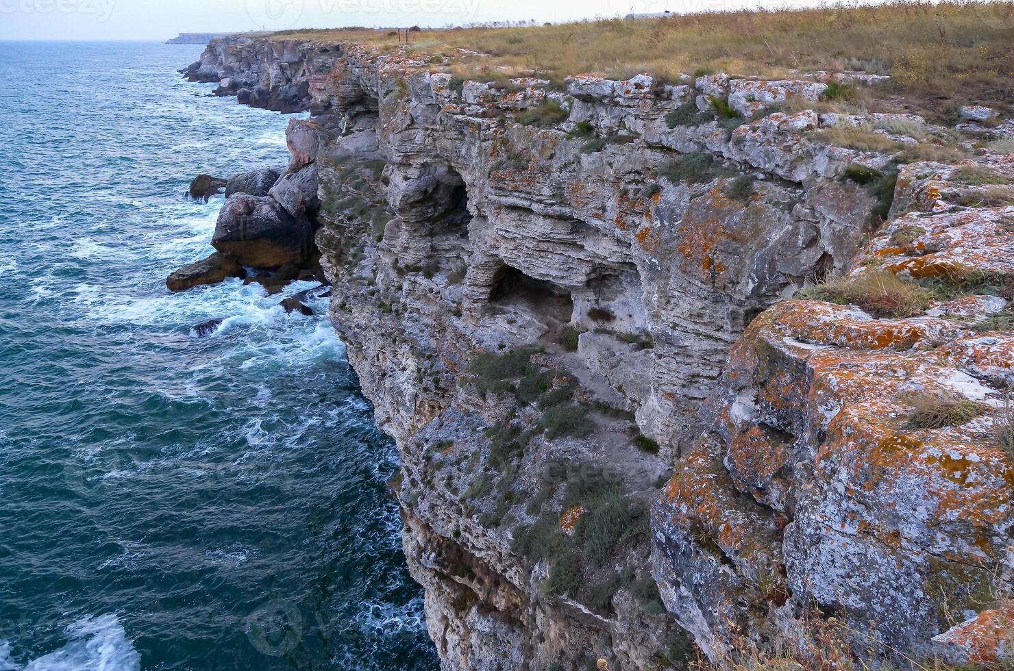 Seascape on the Black Sea, high steep stone coast with inaccessible rocks near the village of Tyulenovo, Bulgaria photo