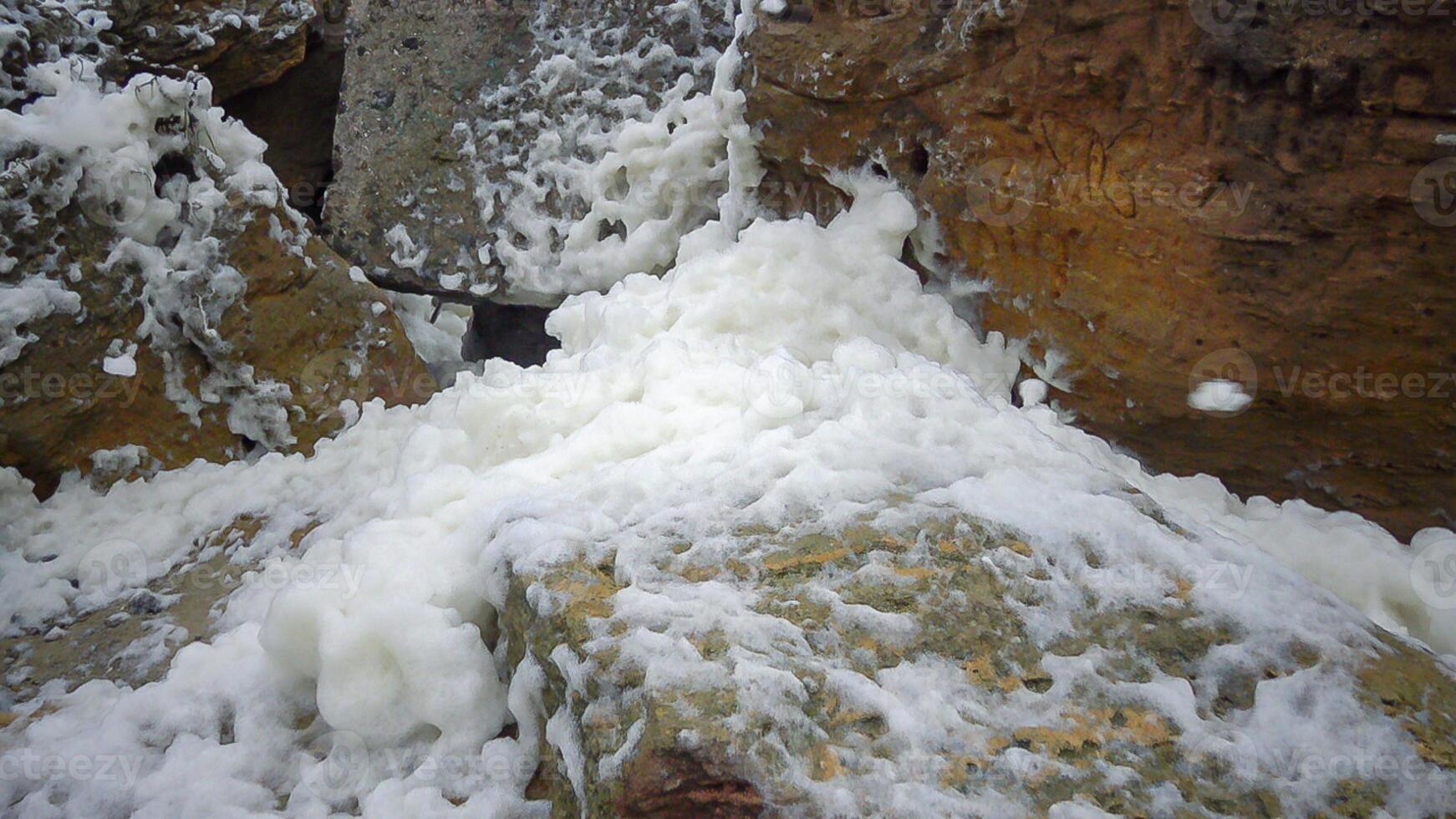 Eutrophication and pollution of the sea, waves with dirty foam roll ashore during a storm, Black Sea photo