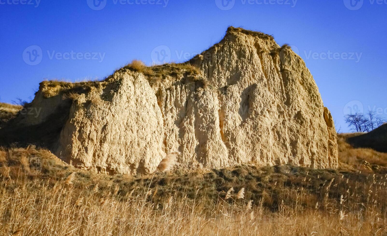 Clay cliffs of the shore of Lake Yalpug against the background of a blue sky photo
