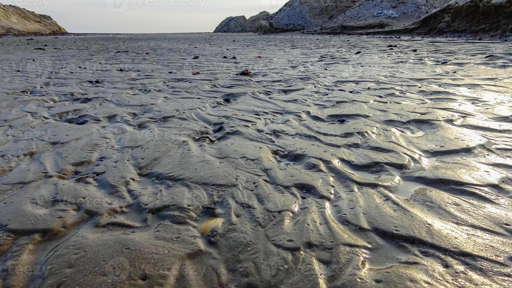 Waves on a muddy bottom in a sea channel at low tide photo
