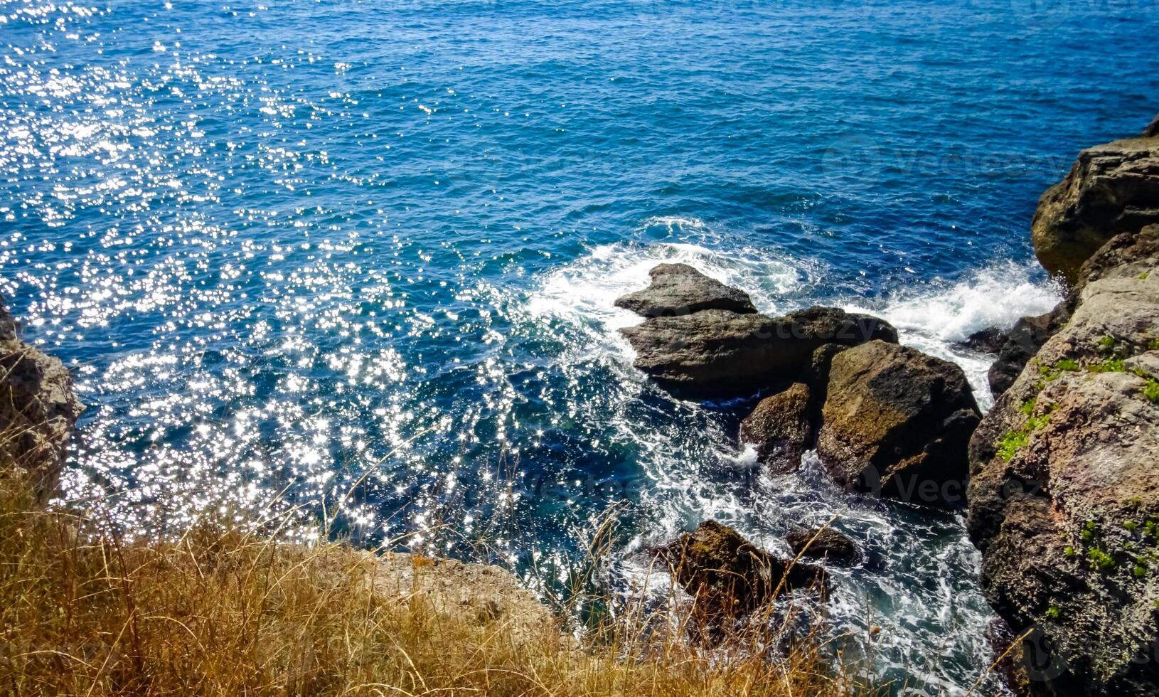Storm at Black sea. Big waves break on the rocky shore, white foam on the water photo