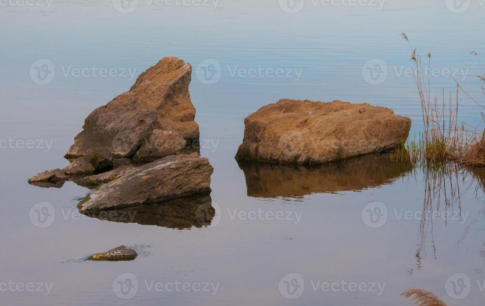 Coast with rocks in the water, Hadzhibey estuary. Reflection in water photo