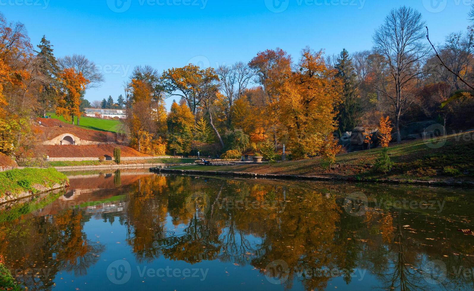 Lake in autumn with reflection in the water of trees against the backdrop of autumn vegetation photo