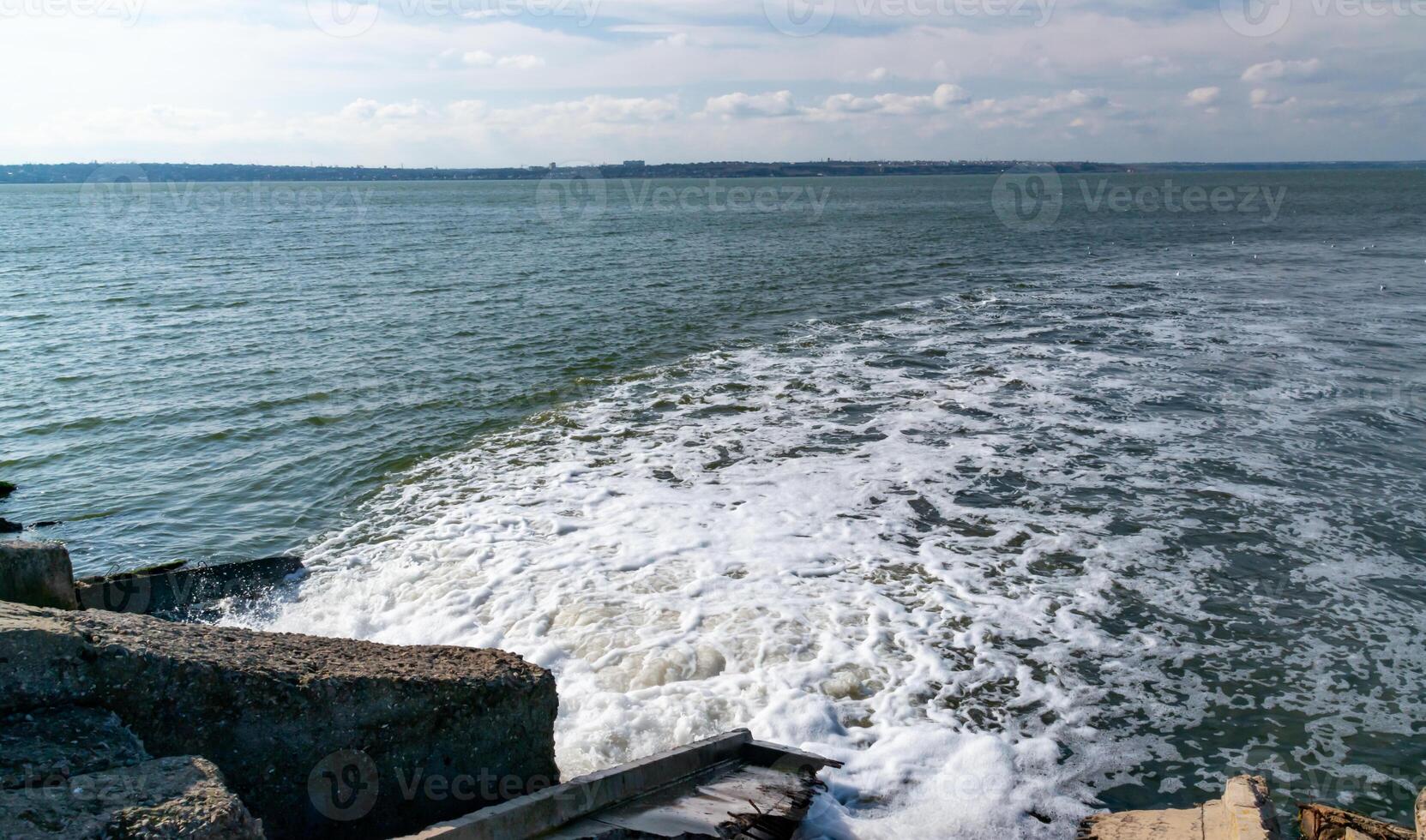 Waste water is poured into the estuary, dirty foam. Ecological problems of the reservoir. Hadzhibey estuary, Ukraine photo