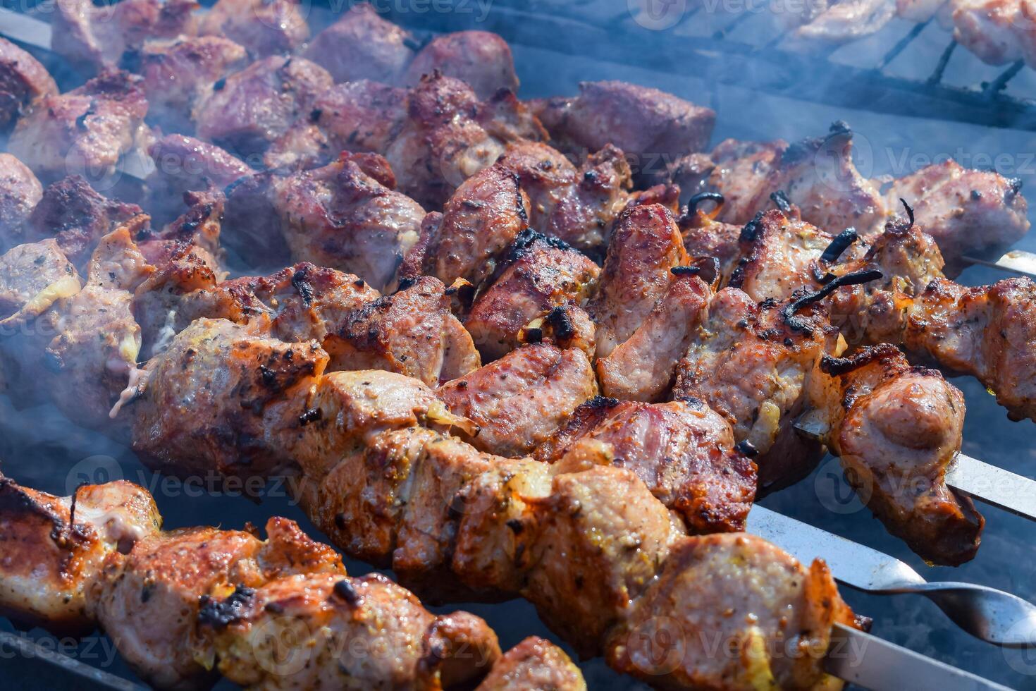 Pork meat is fried on smoking coals in the grill photo