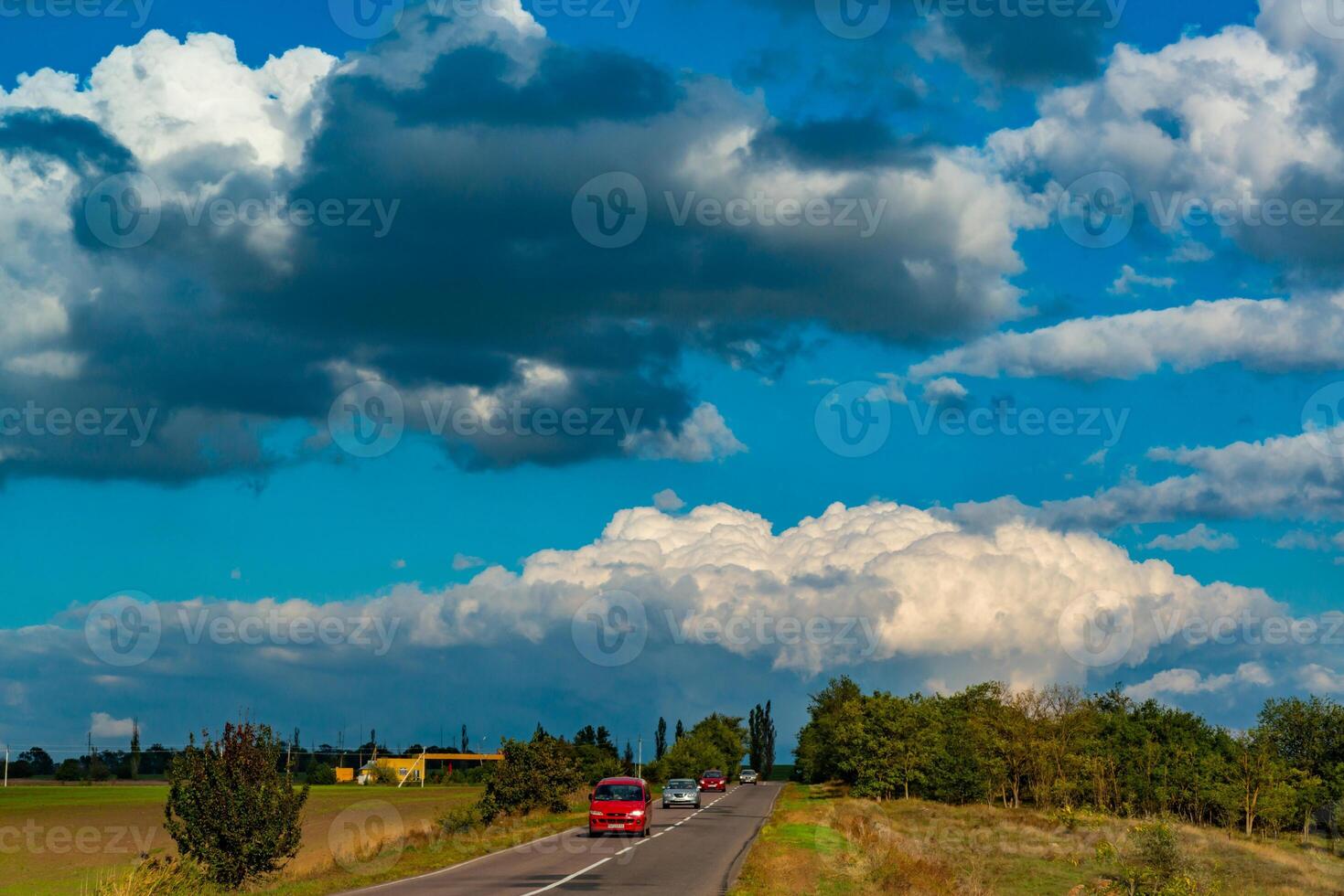 White cumulus thunderclouds in the sky over a highway, Ukraine photo
