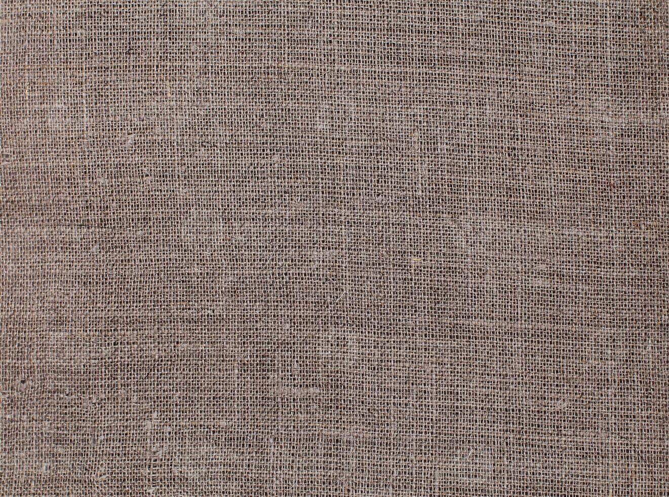Natural Linen Material Textile Canvas Fabric Texture Background Close-up Detail of Fabric Natural Color Hemp Material Pattern Design Wallpaper. Can be Used as Background or For Graphic Design photo