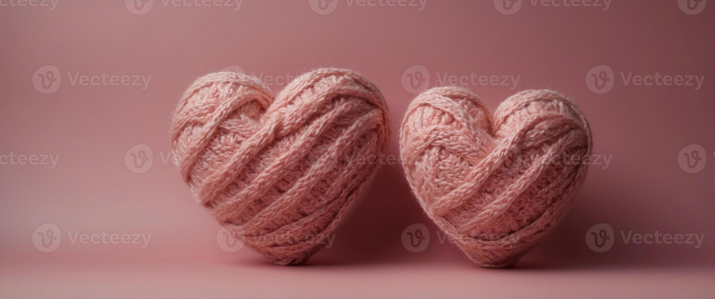 Knitted heart of pink color on a pink background. photo