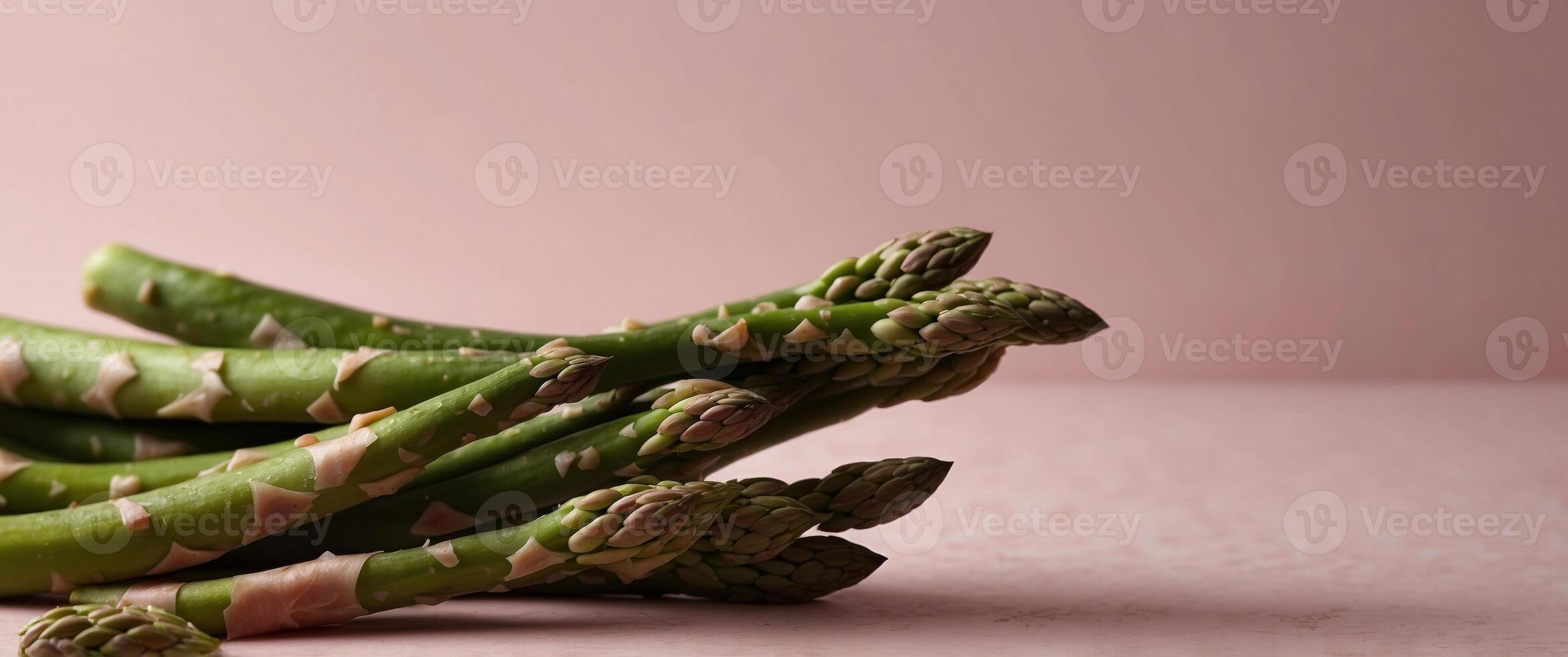 Fresh green asparagus on a pink background with copy space. photo