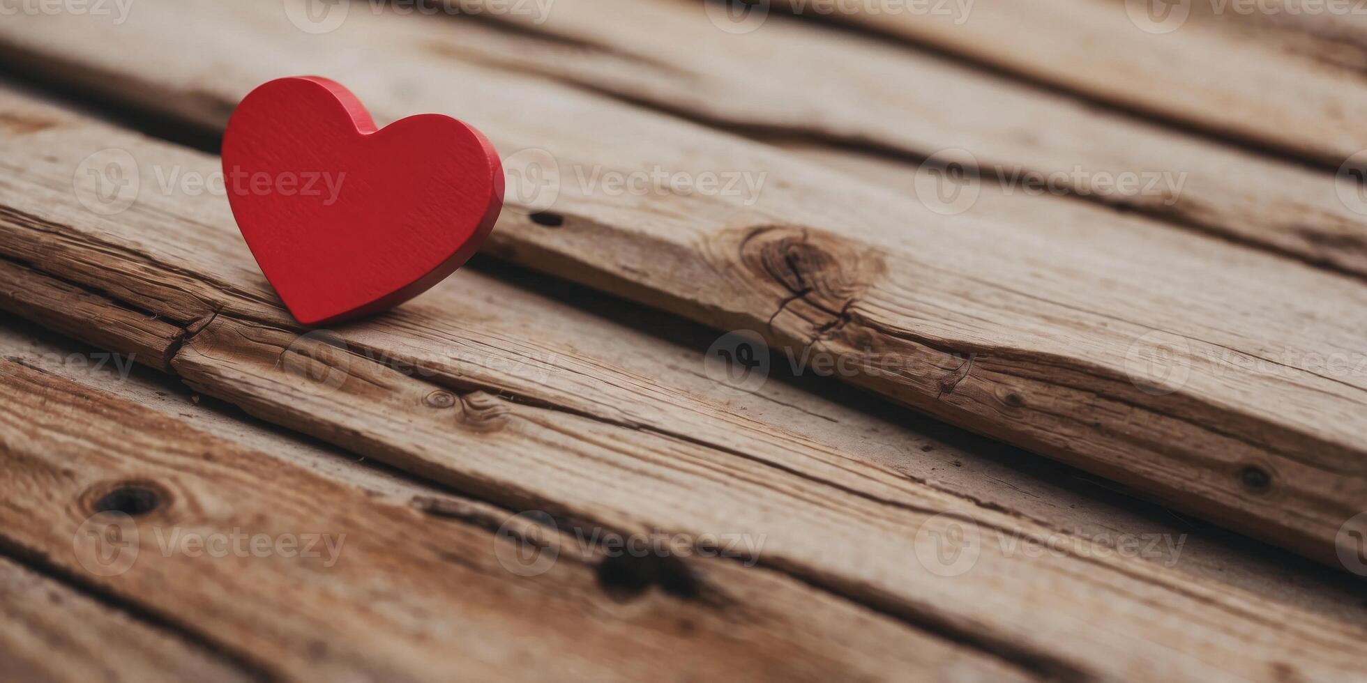 a red heart shaped object sitting on top of a piece of wood on top of a piece of plywood. photo