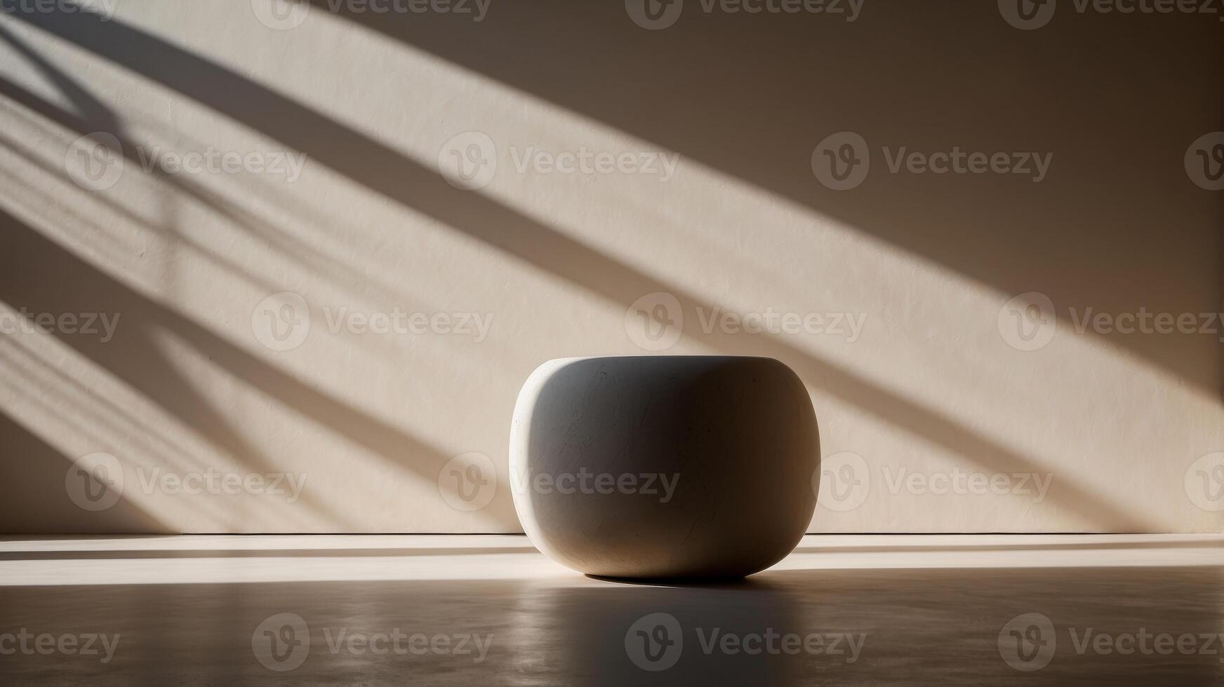 A round stone pedestal with a shadow on the wall behind it. photo