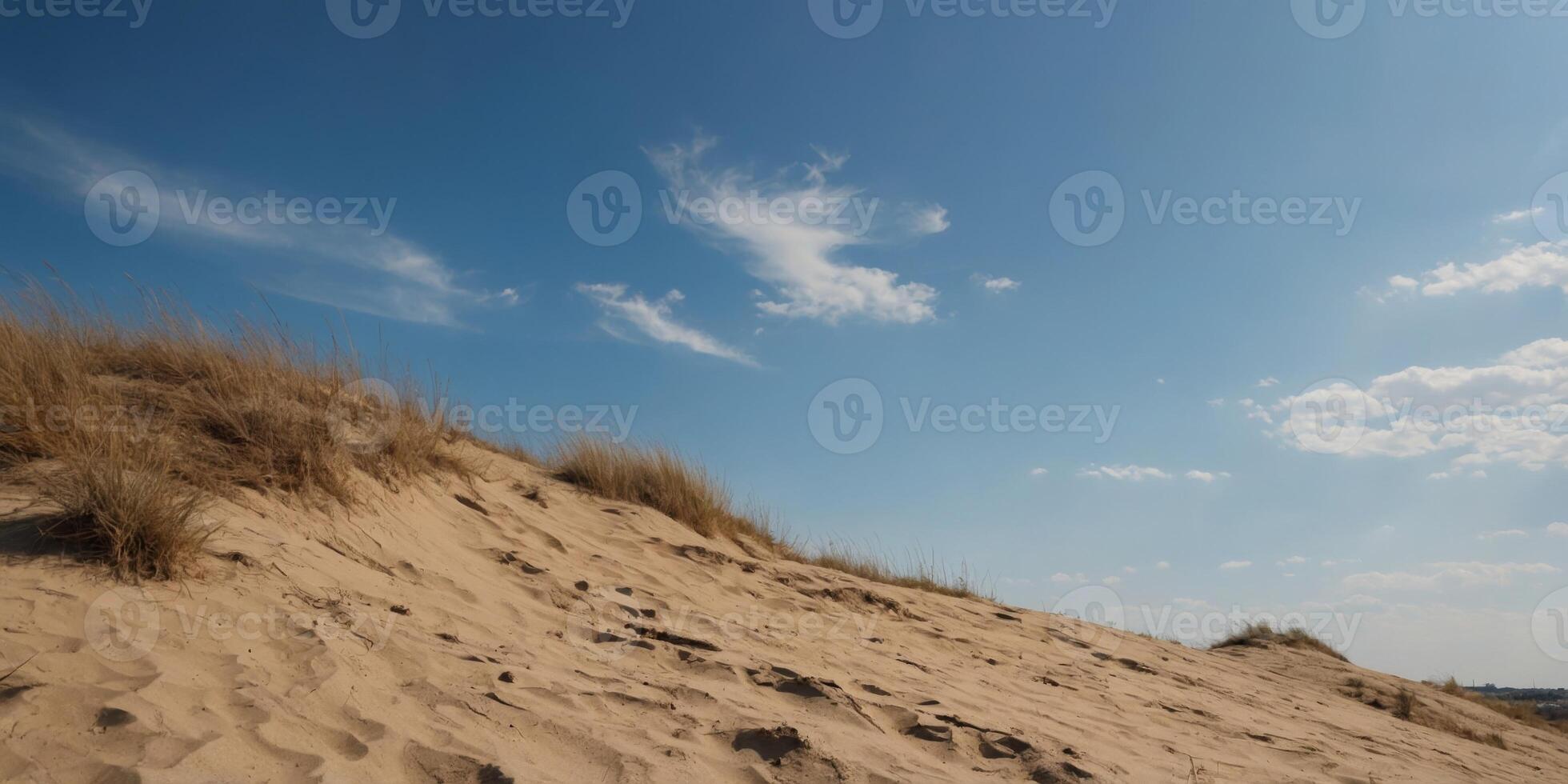A sandy hill with a blue sky in the background. photo