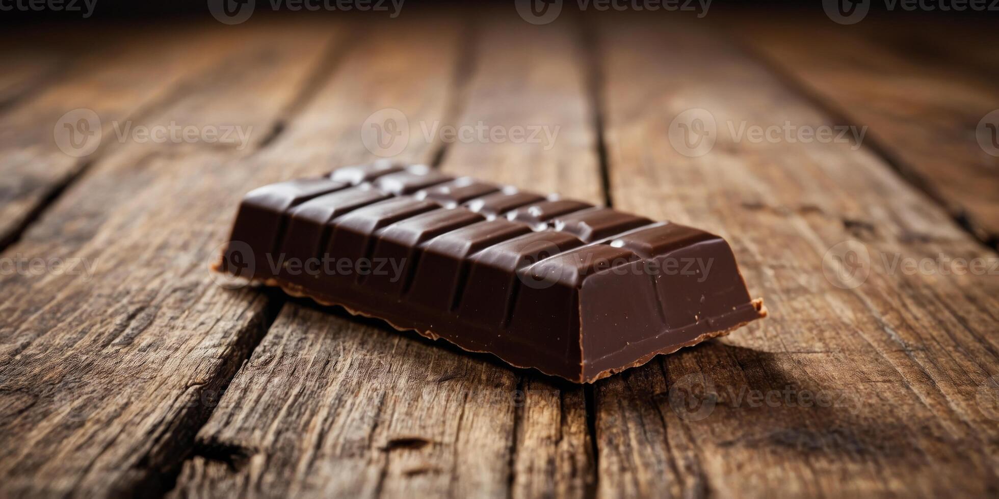 A chocolate bar is sitting on a wooden table. photo