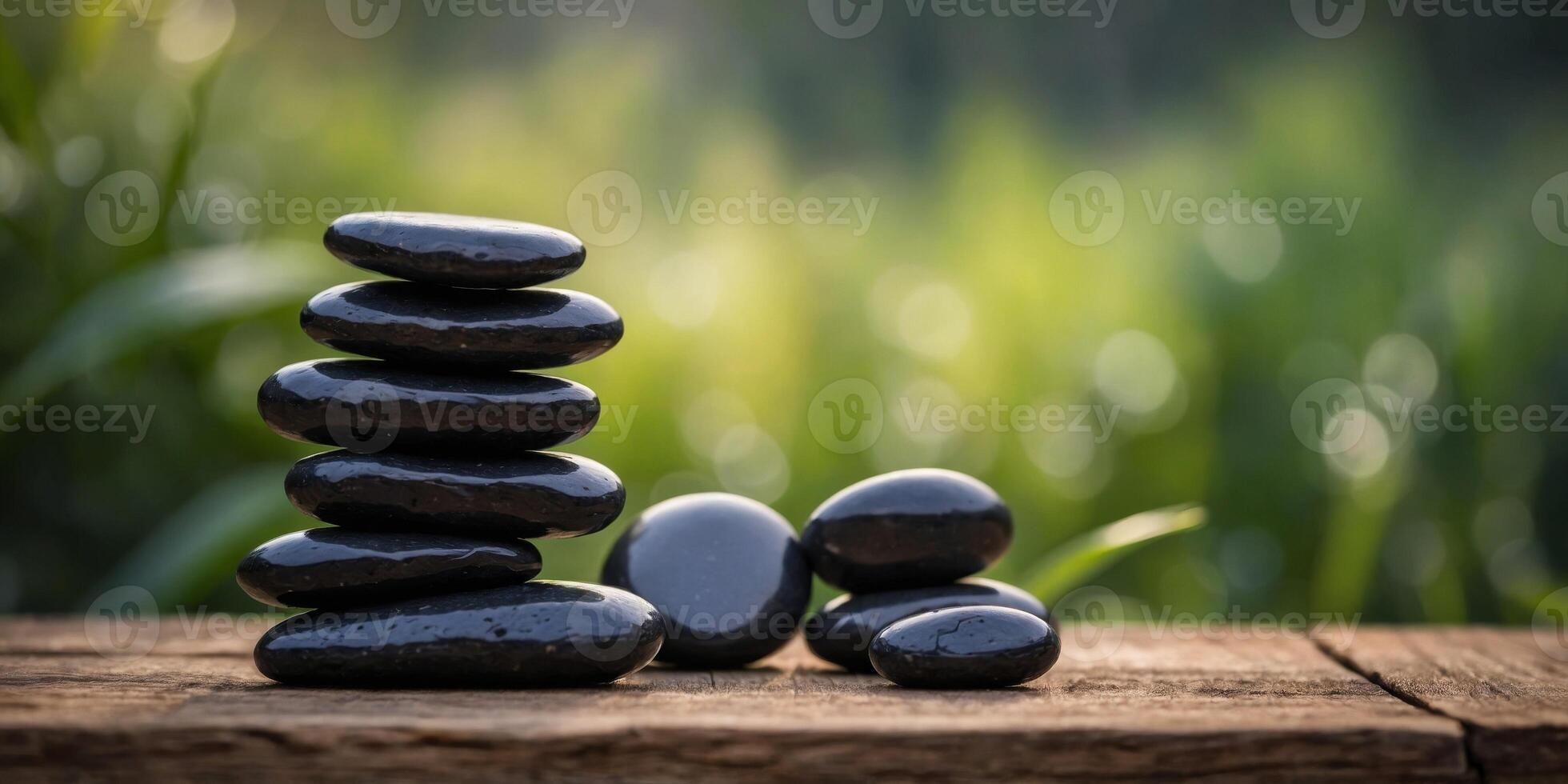 A stack of black stones on a wooden table. photo