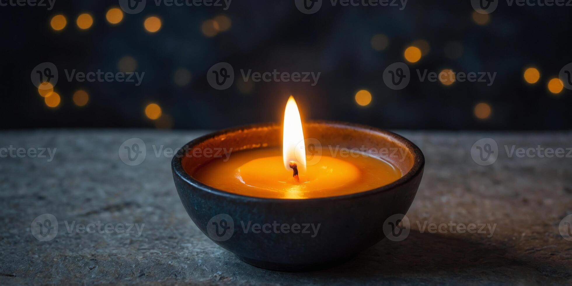 A candle is lit in a small bowl on a stone ledge. photo