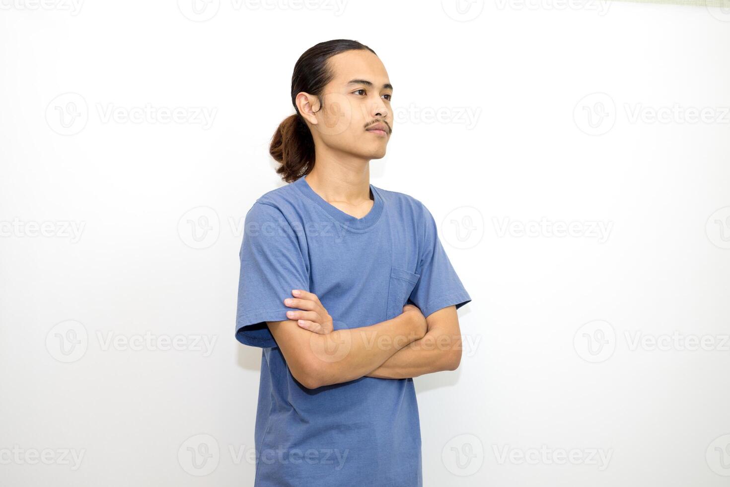Smiling Asian man wearing dark blue t-shirt standing with arms crossed facing sideways. isolated in white background photo