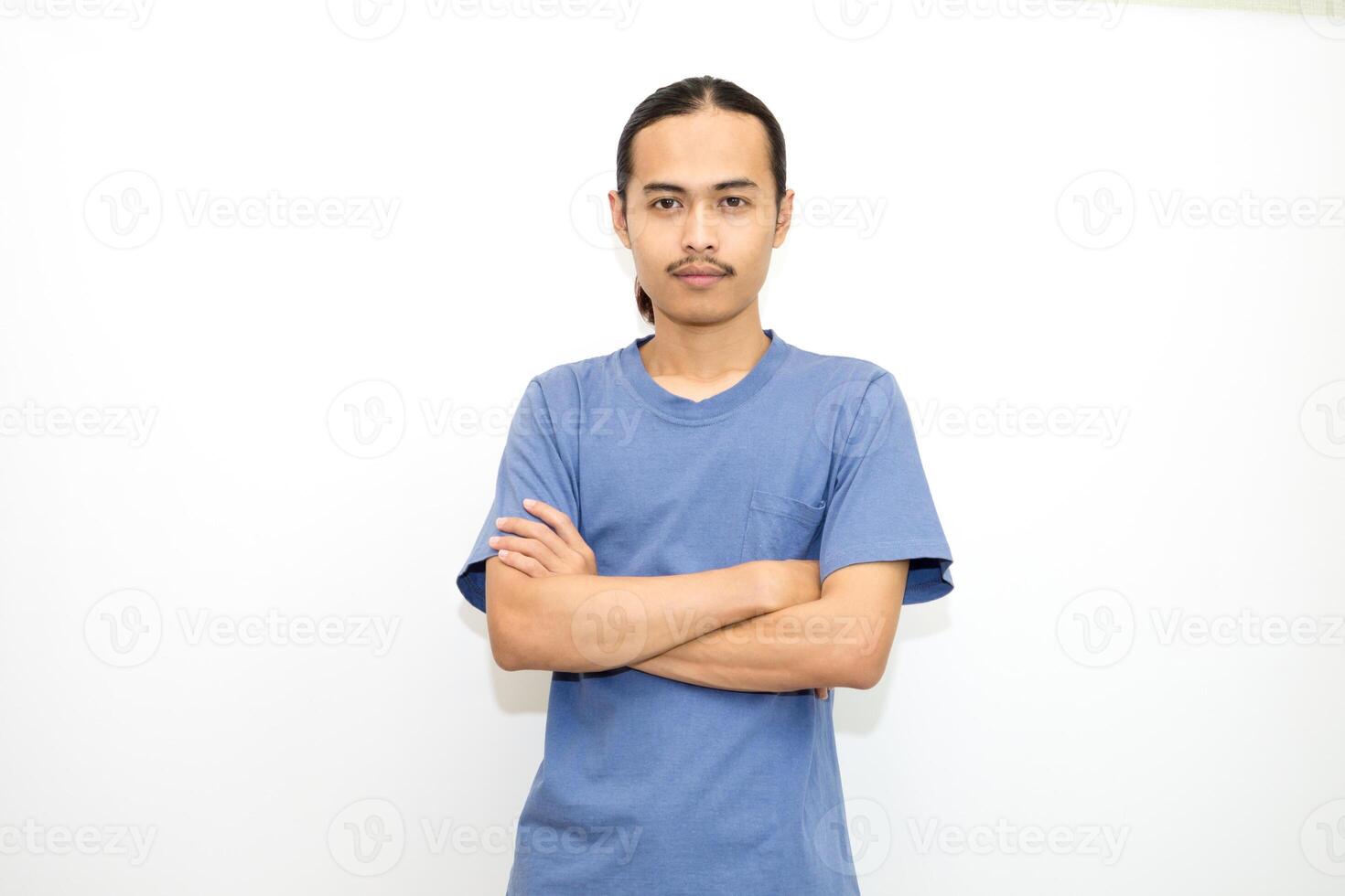 Smiling Asian man wearing dark blue t-shirt standing with arms crossed facing front. isolated in white background photo