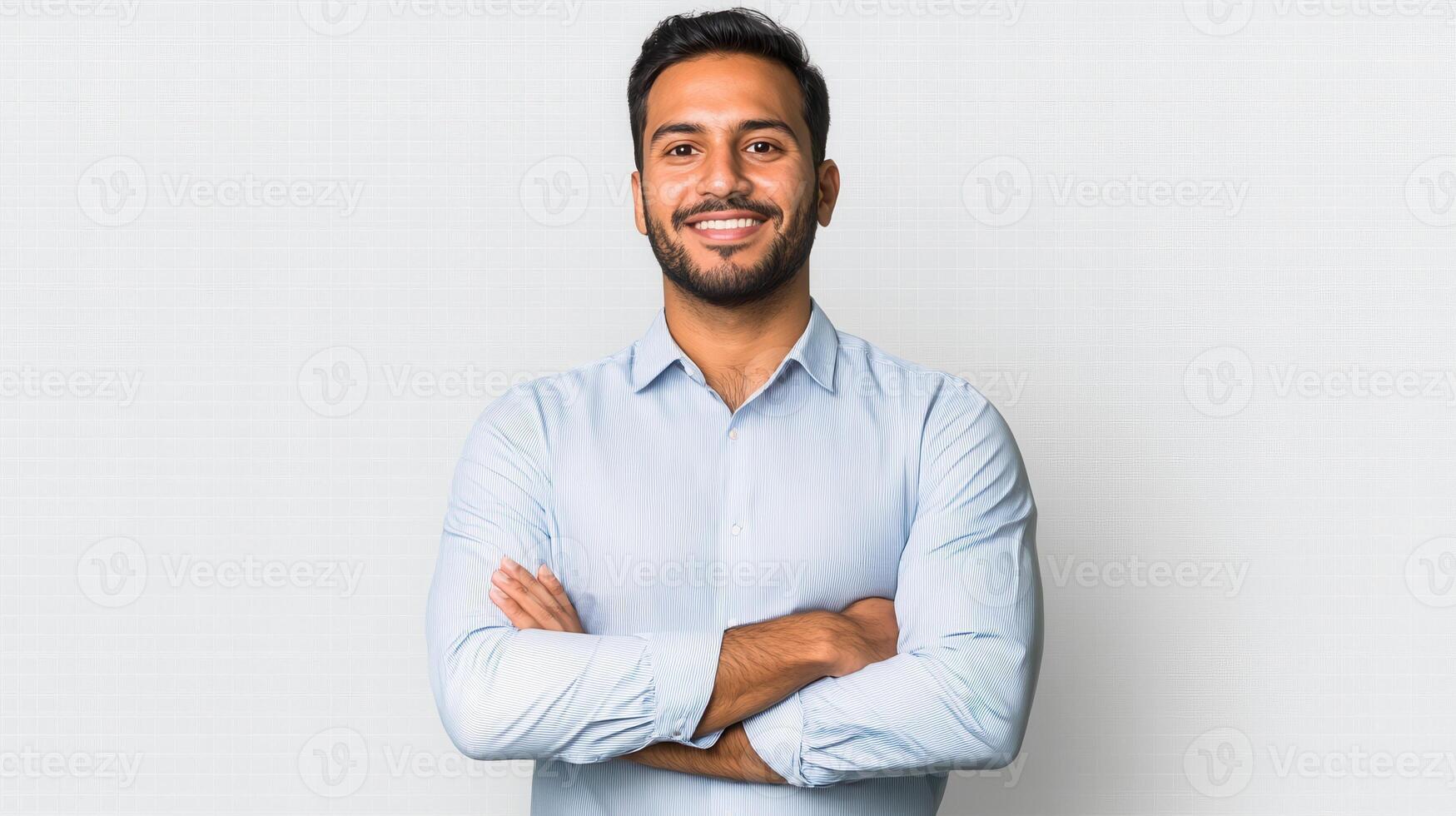 A cheerful Indian businessman in casual clothes standing proudly. photo