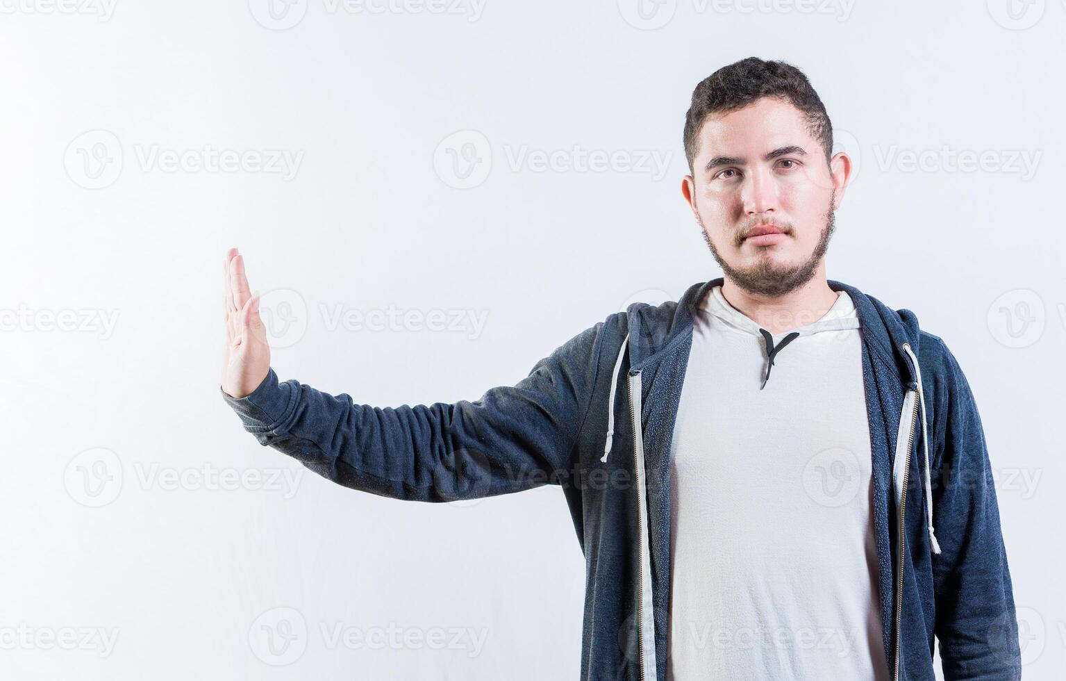 Young man making rejection gesture with palm of hand isolated. Displeased person rejecting gesturing stop isolated photo